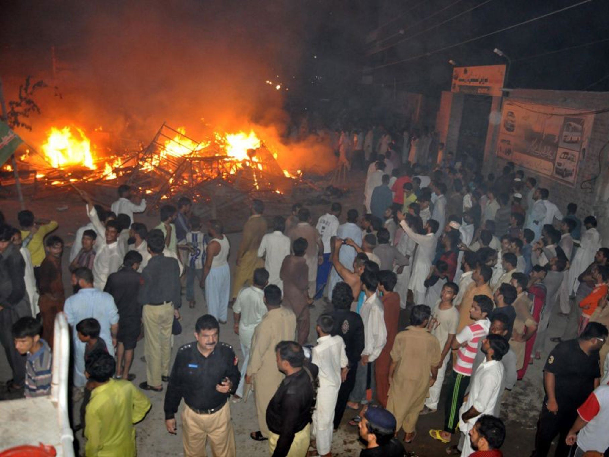 Police arrive after the houses of religious minority group Ahmadiyyas, were torched by a mob following accusations of blasphemy, in Gujranwala, Pakistan, 28 July 2014