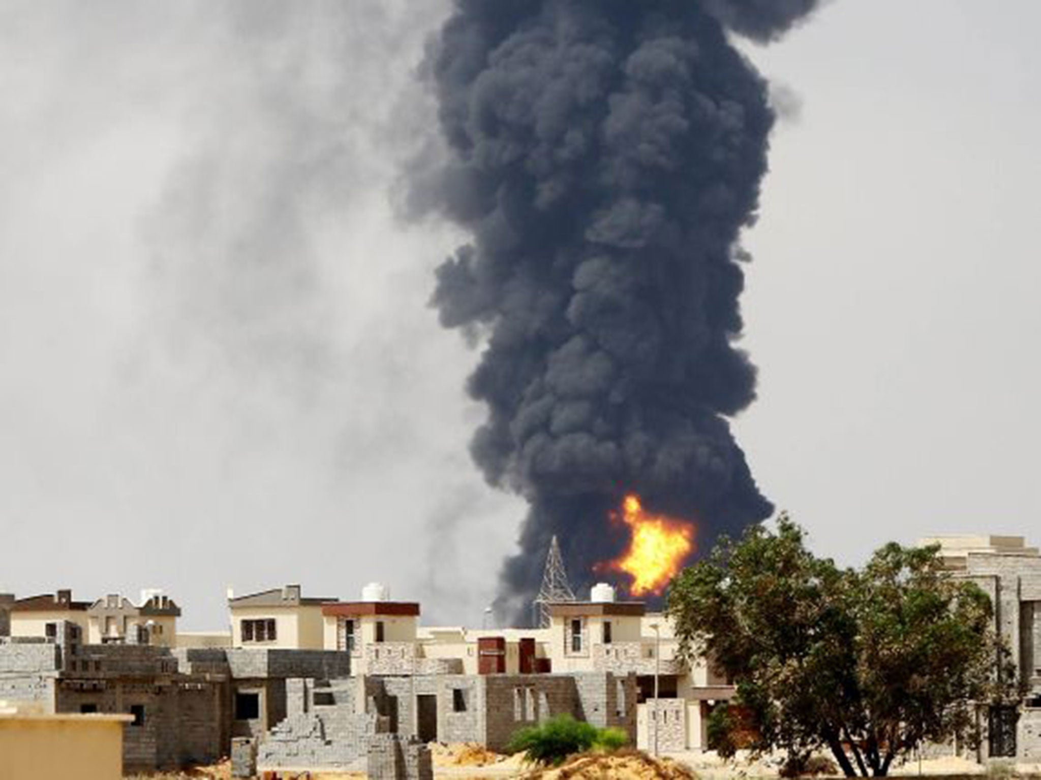 Smoke billows from the oil depot following clashes near Tripoli airport