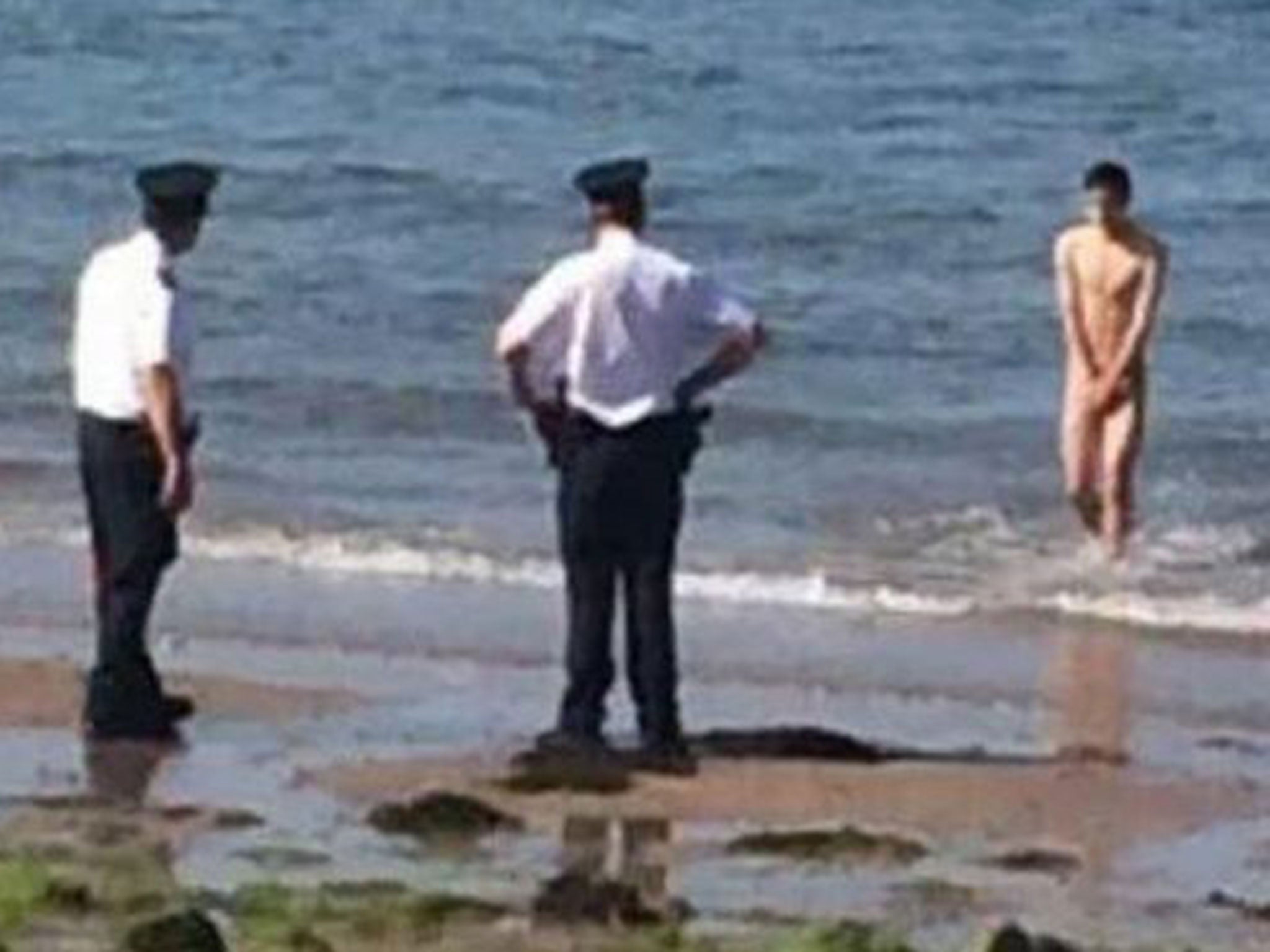 Gardai wait for the naked man, who had gone for a skinny dip in Belfast Lough