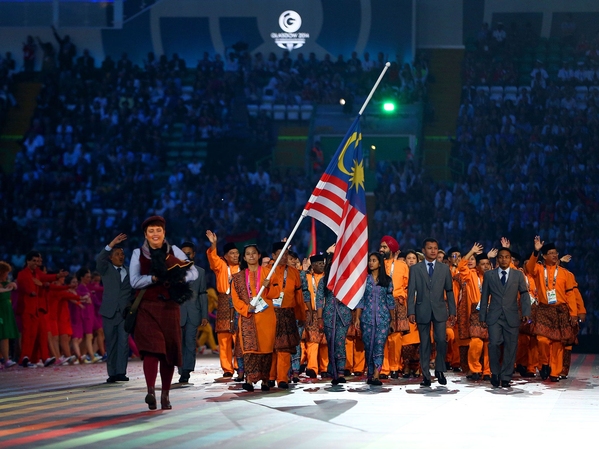 Flag bearer and Cyclist Fatehah Mustapa of Malaysia flies the flag at half mast during the Opening Ceremony for the Glasgow 2014 Commonwealth Games