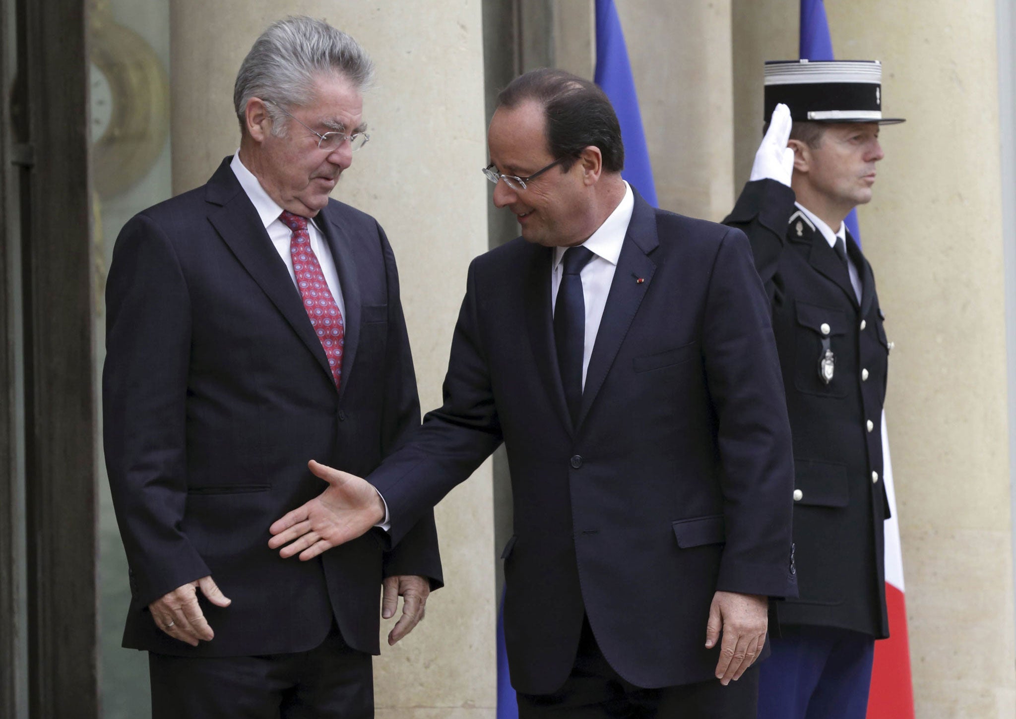Awkward positioning: Francois Hollande goes for a handshake with Austrian President Heinz Fischer but misses the target