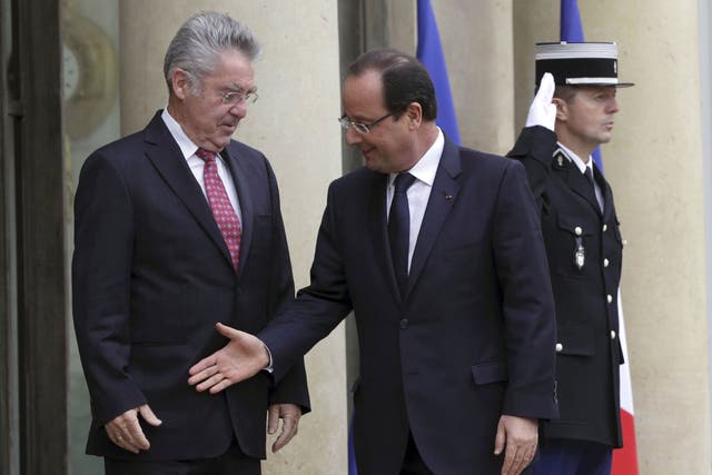 Awkward positioning: Francois Hollande goes for a handshake with Austrian President Heinz Fischer but misses the target