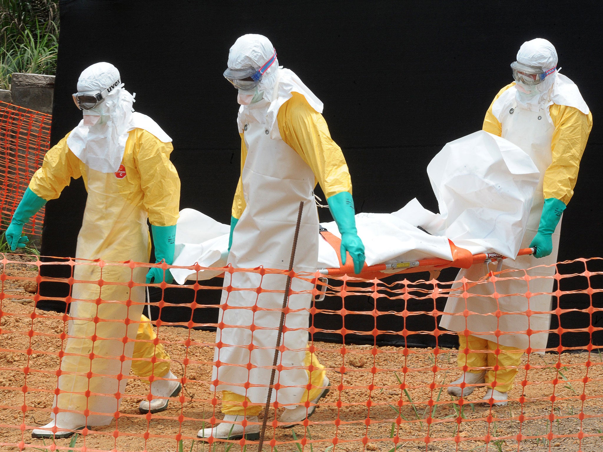 Staff of 'Médecins sans frontières' carry the body of a person killed by viral haemorrhagic fever, at a center for victims of the Ebola virus in Guekedou, on April 1, 2014.