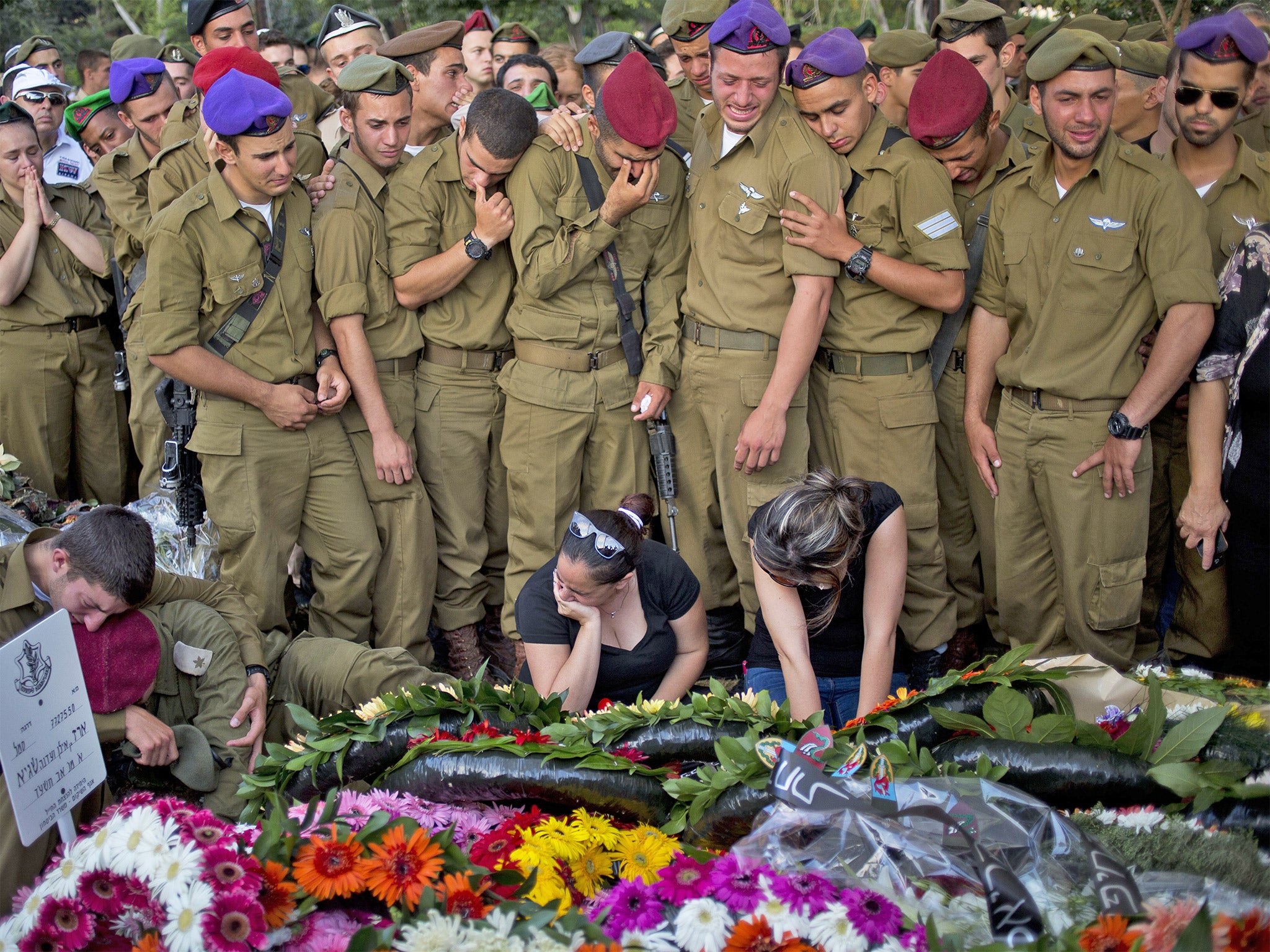 Israeli soldiers, family and friends mourn at the grave of Sergeant Sagi Erez, 19, during his funeral in Haifa