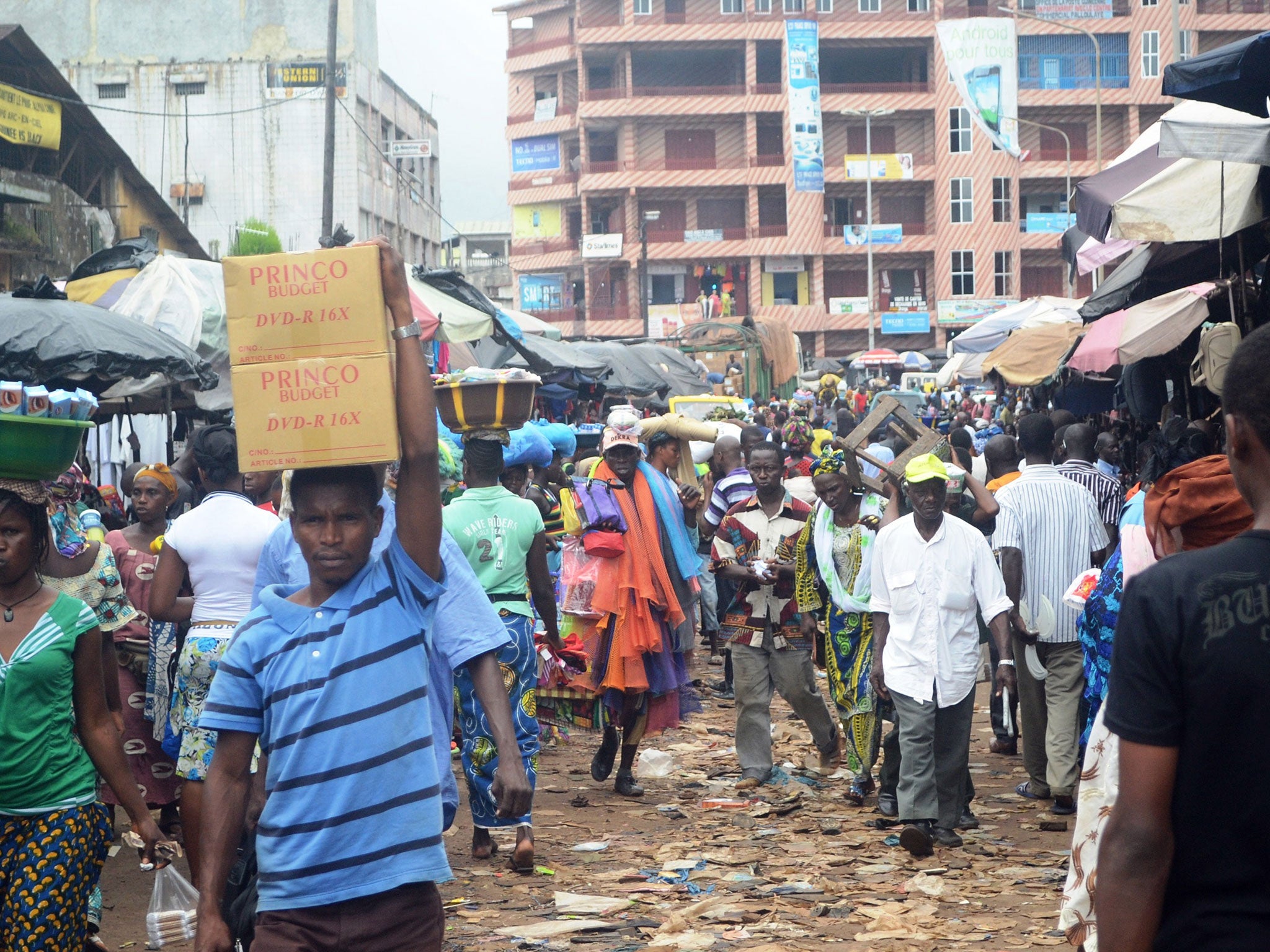 People walking in a street in the capital of Guinea, Conakry. The Presidency has declared a week of mourning after 24 people were killed in a stampede at a concert in the Ratoma neighbourhood of the city, held to celebrate the end of Ramadan