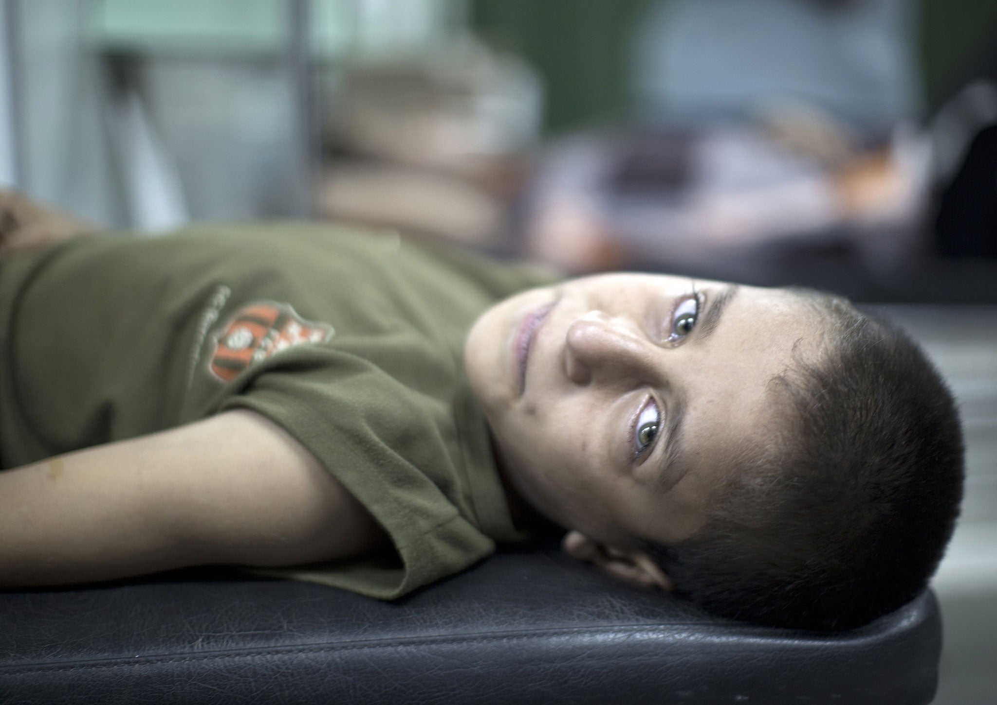 A Palestinian boy who was wounded in an Israeli strike on a compound housing a UN school in Jabalia refugee camp in the northern Gaza Strip, waits for treatment at the Kamal Edwin hospital in Beit Lahia