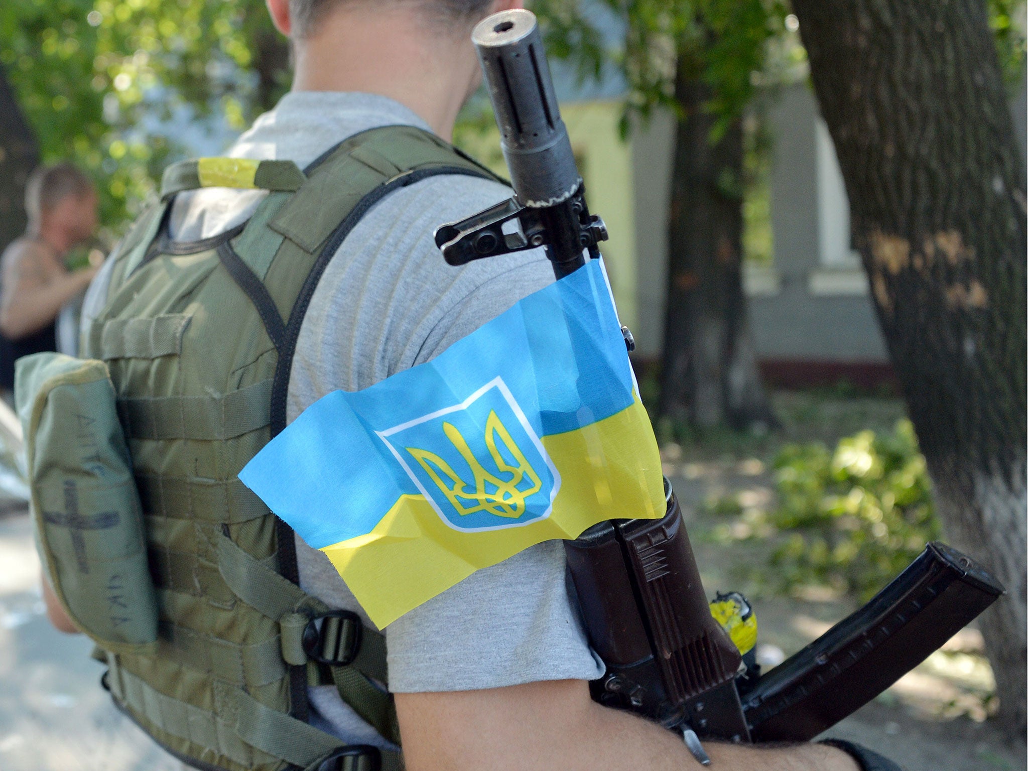 A member of the pro-Ukraine Donbass Battalion holds an automatic rifle with Ukraine's national flag attached to it, while patroling the outskirts of the eastern Ukrainian city of Lysychansk. Ukrainian troops have retaken the strategically-important city o