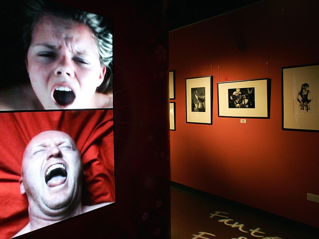 A screen showing men and women as they orgasm is seen at Amora Sex Acadamy, an attraction about sexual relationships, London, April 2007