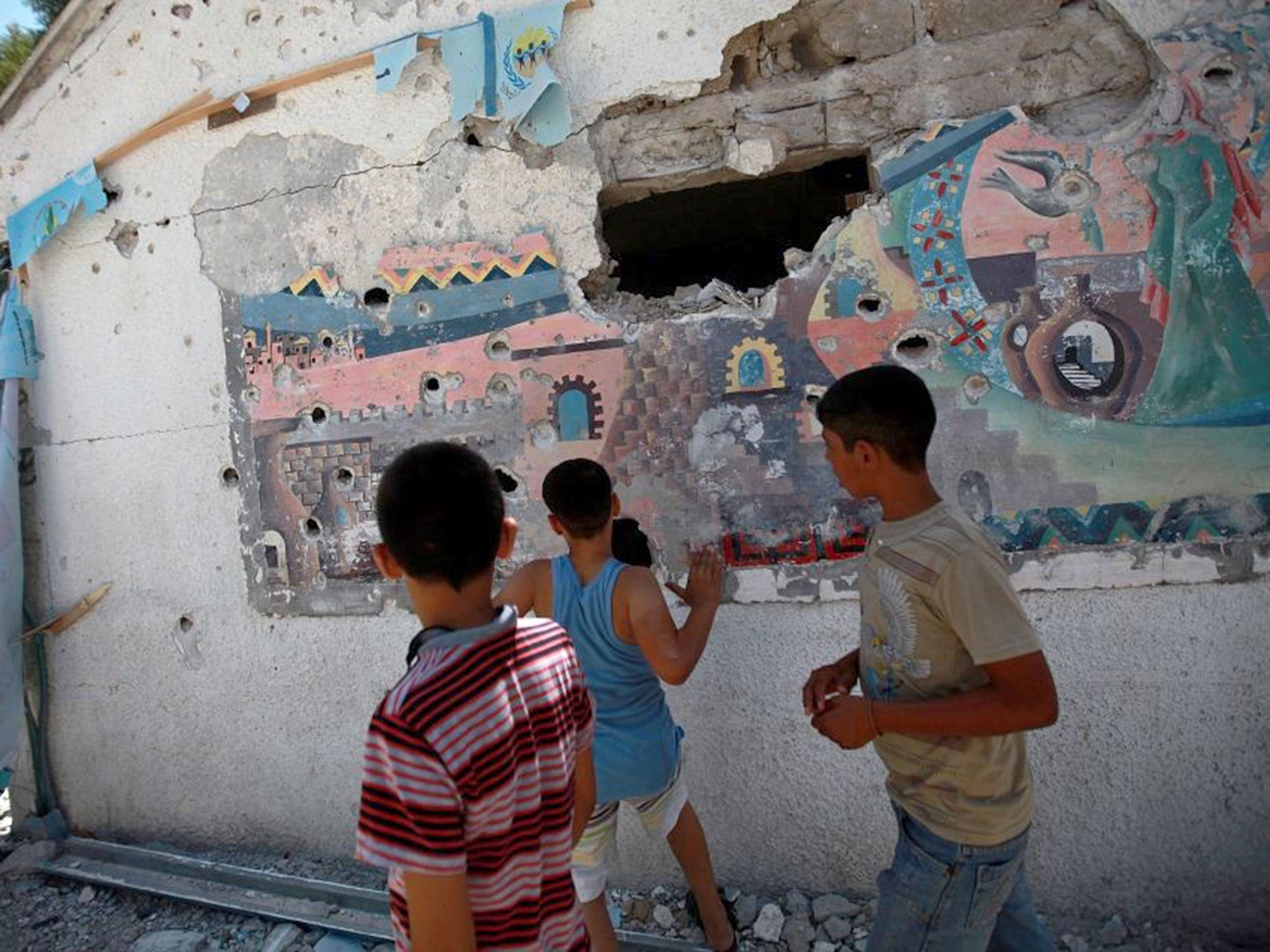 Palestinians youths inspect a destroyed classroom of a UN school in Jabalia, northern Gaza Strip, 30 July 2014. Dozens of Palestinians were killed in another night of heavy airstrikes and artillery on the Gaza Strip overnight, including the deadly shellin