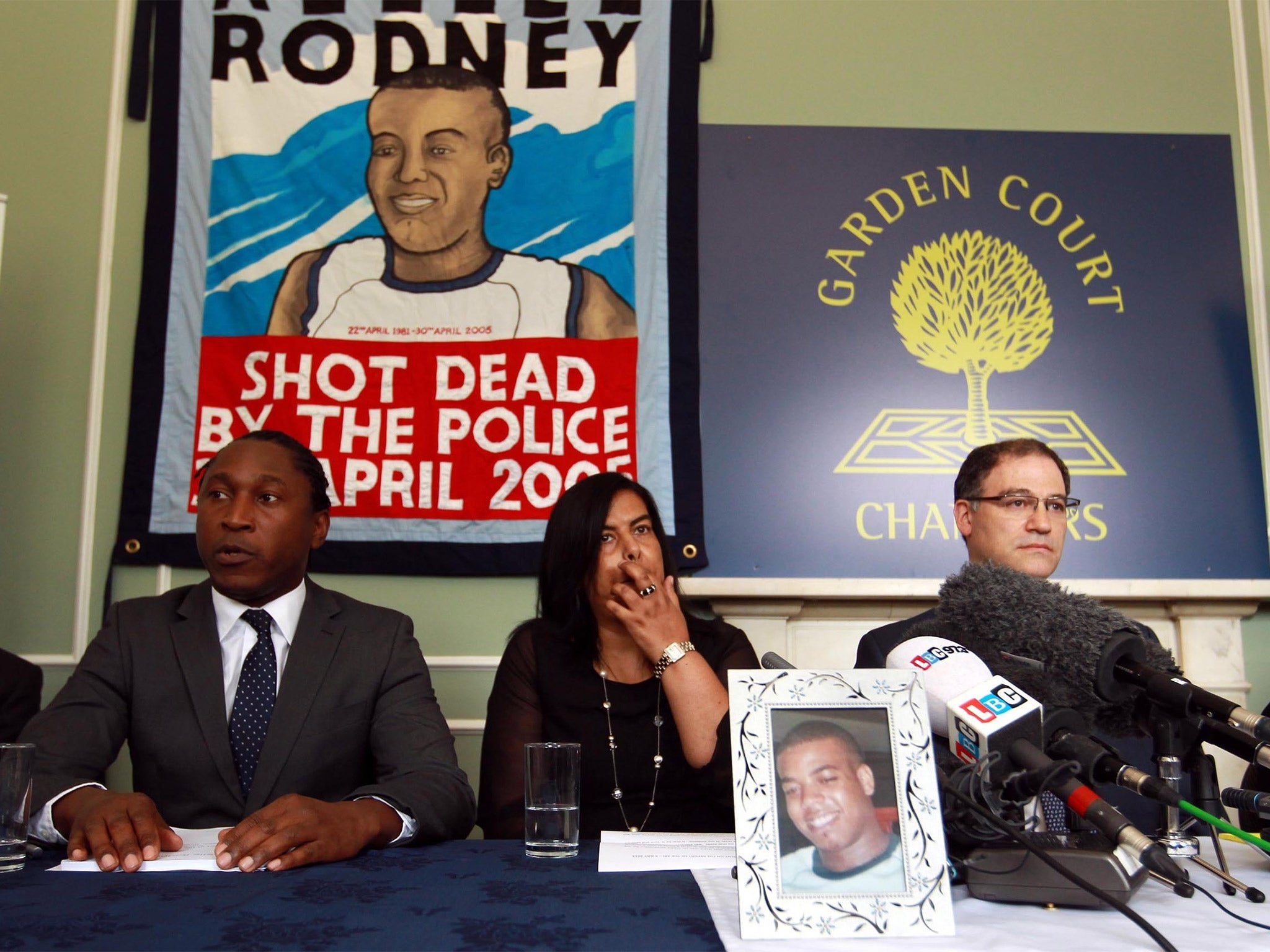 Susan Alexander sits behind a photograph of her son Azelle, at a press conference last year