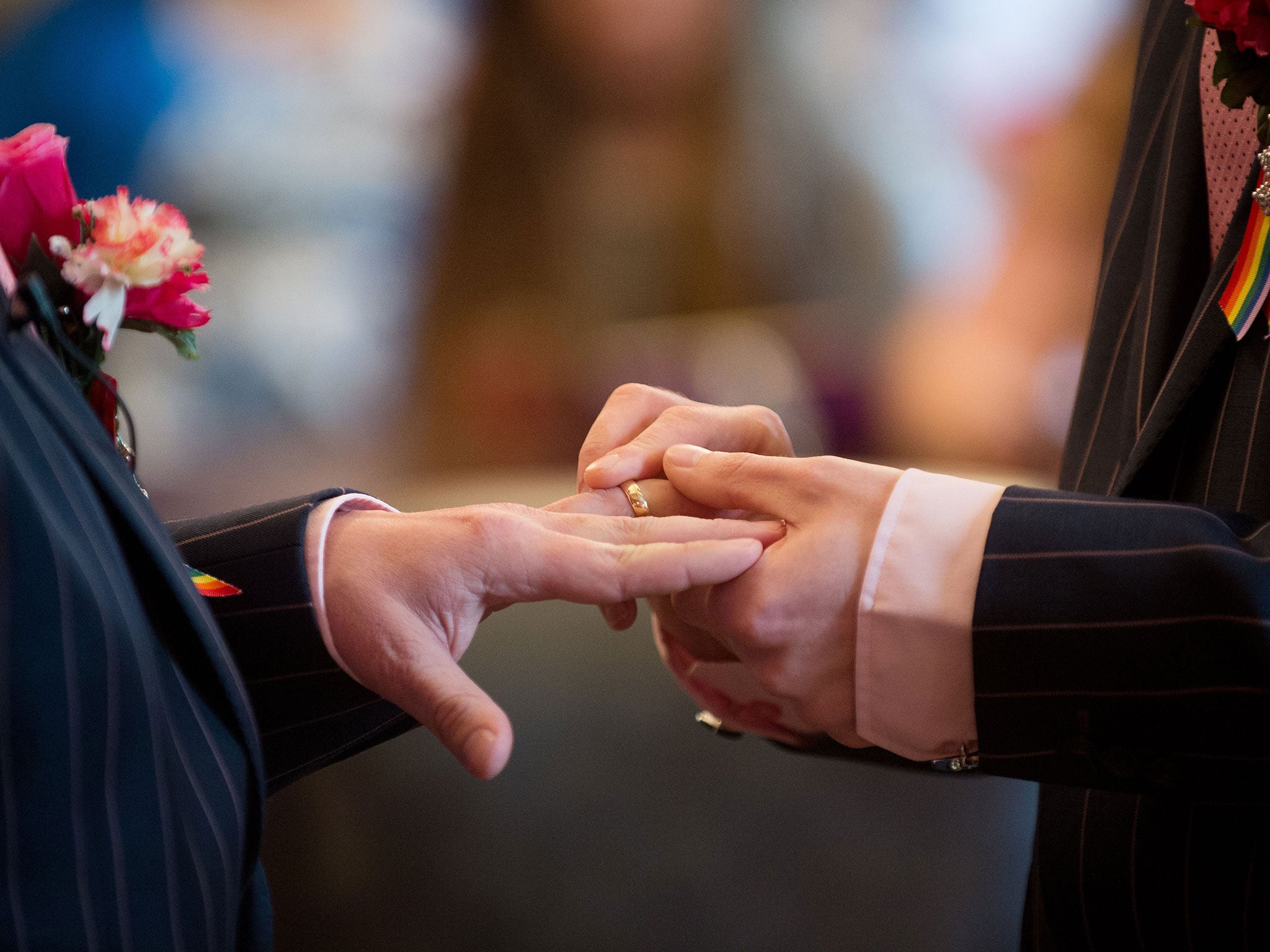 To grooms exchange rings during their wedding ceremony in Brighton