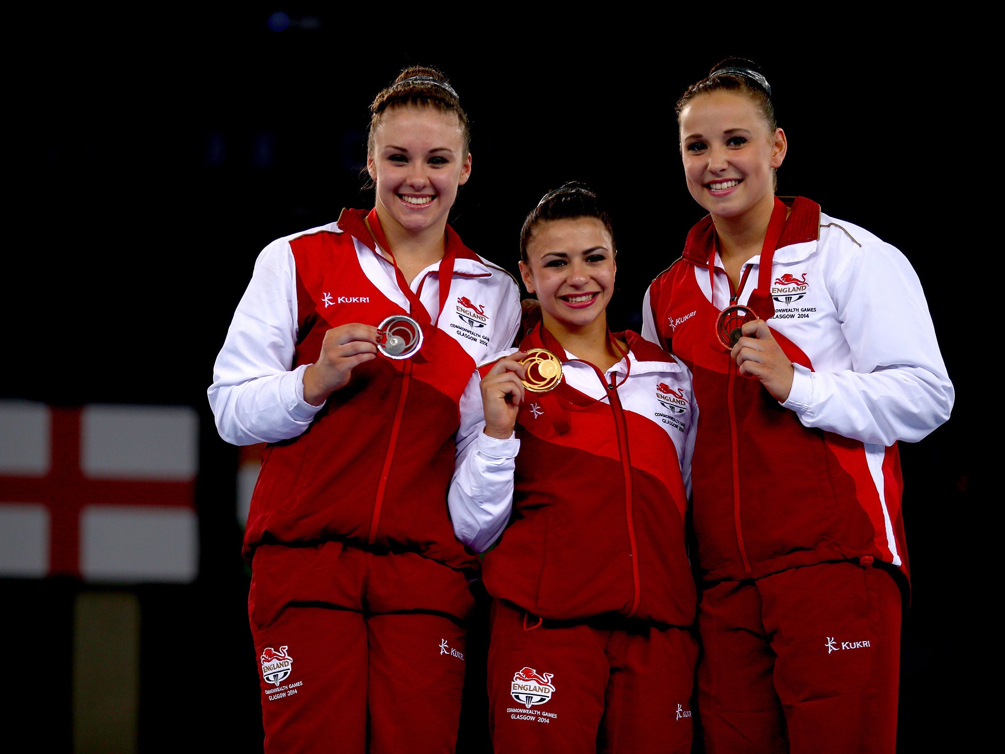 Claudia Fragapane of England poses on the podium with Ruby Harrold and Hannah Whelan of England after winning the Women's All-Around Final