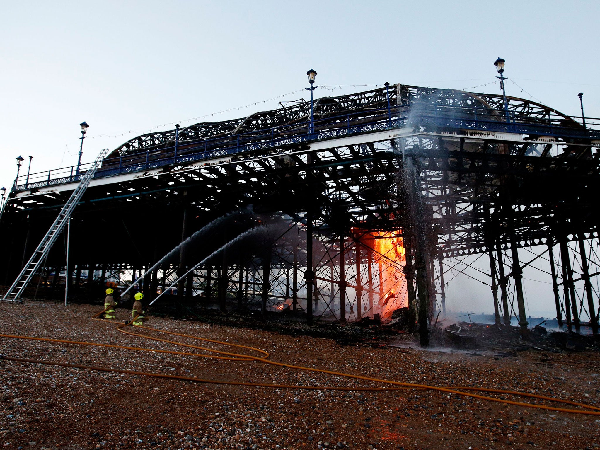 Firemen continue to tackle the final flames of a fire at Eastbourne Pier on Wednesday night