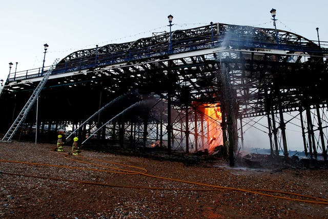 Firemen continue to tackle the final flames of a fire at Eastbourne Pier. 