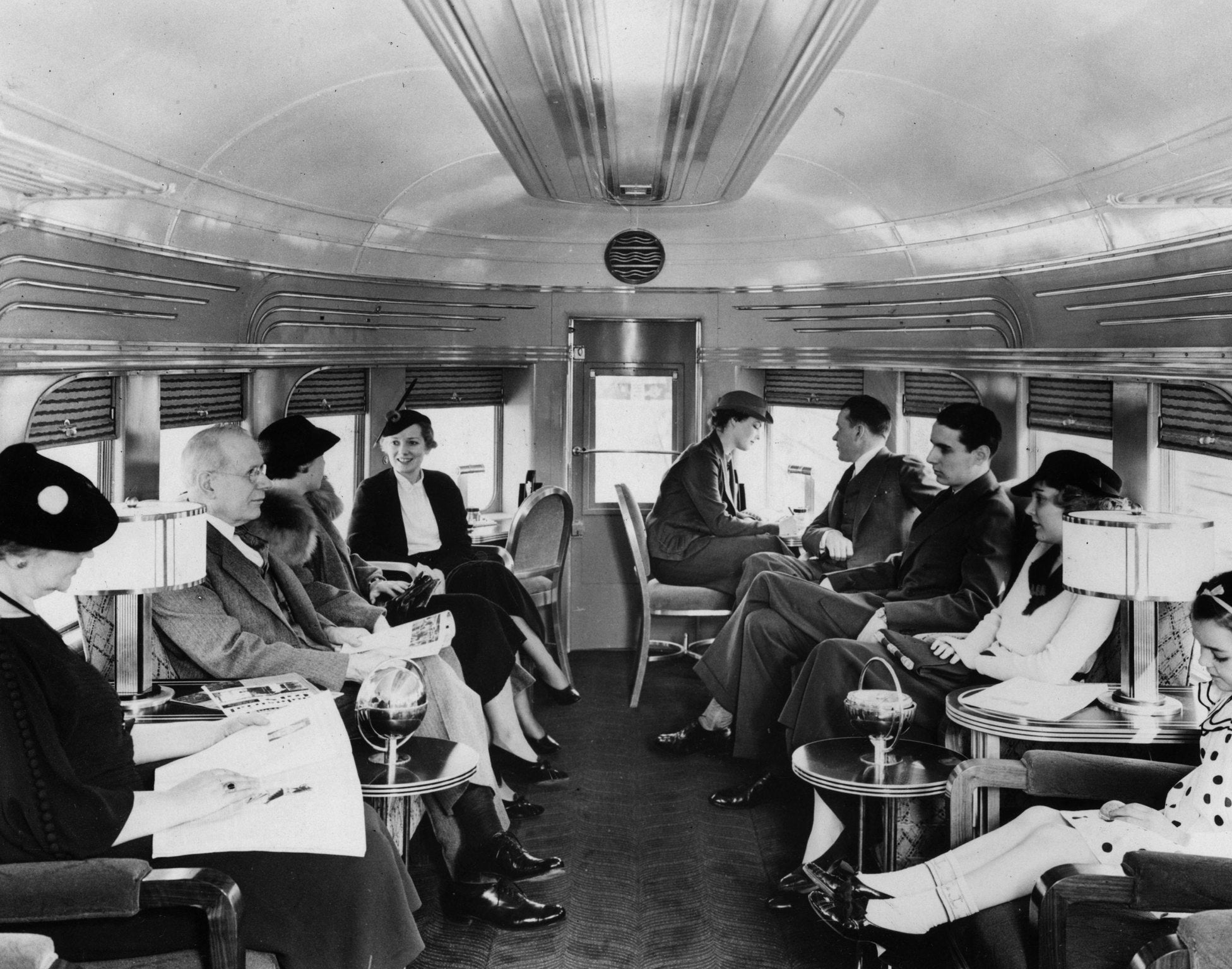 Passengers sit and enjoy a quiet train journey in a bygone age