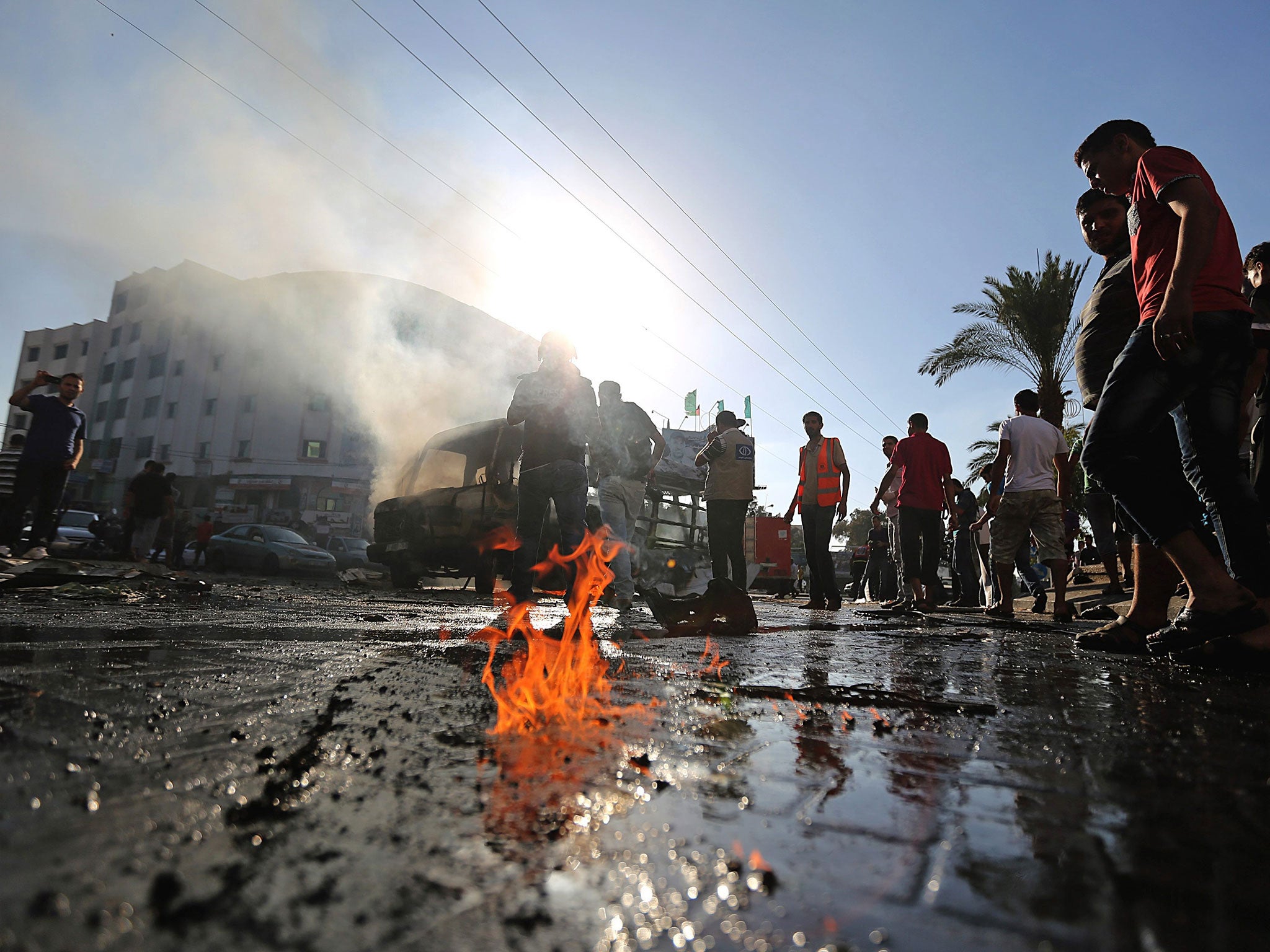 Palestinians inspect a destroyed bus after Israeli airstrikes in the central Gaza City