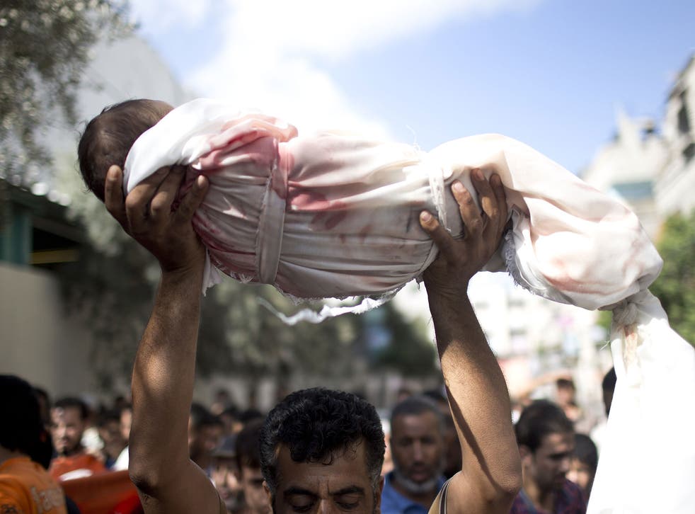 A Palestinian man carries the body of a one-year-old baby Noha Mesleh, who died of wounds sustained after a UN school in Beit Hanun was hit by an Israeli tank shell