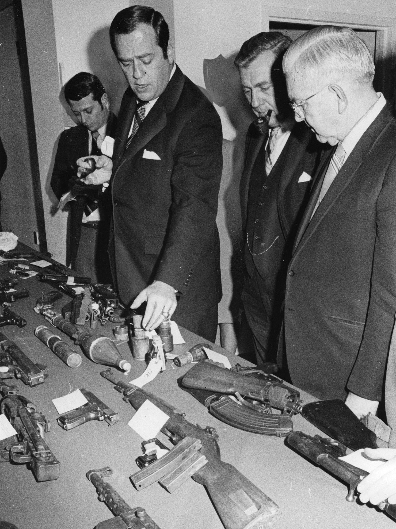 Ambrose (second left) in 1970, inspects weapons seized by customs officers