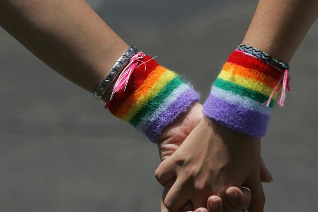 A lesbian couple hold hands during the annual Gay Pride rally