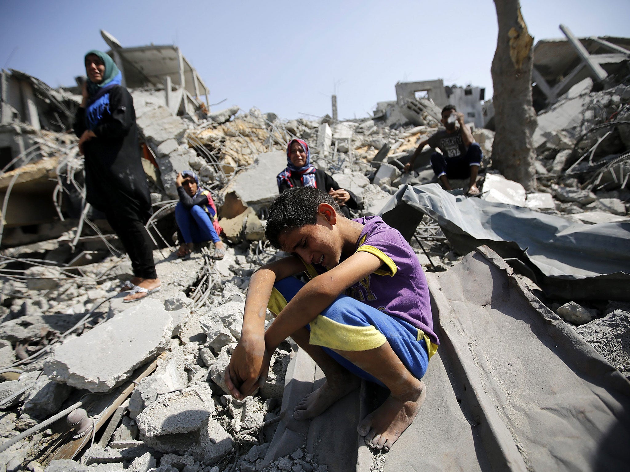 Ahmad Al Kafarna, aged 7, cries on the remains of his home in Beit Hanun, the northern Gaza Strip, yesterday