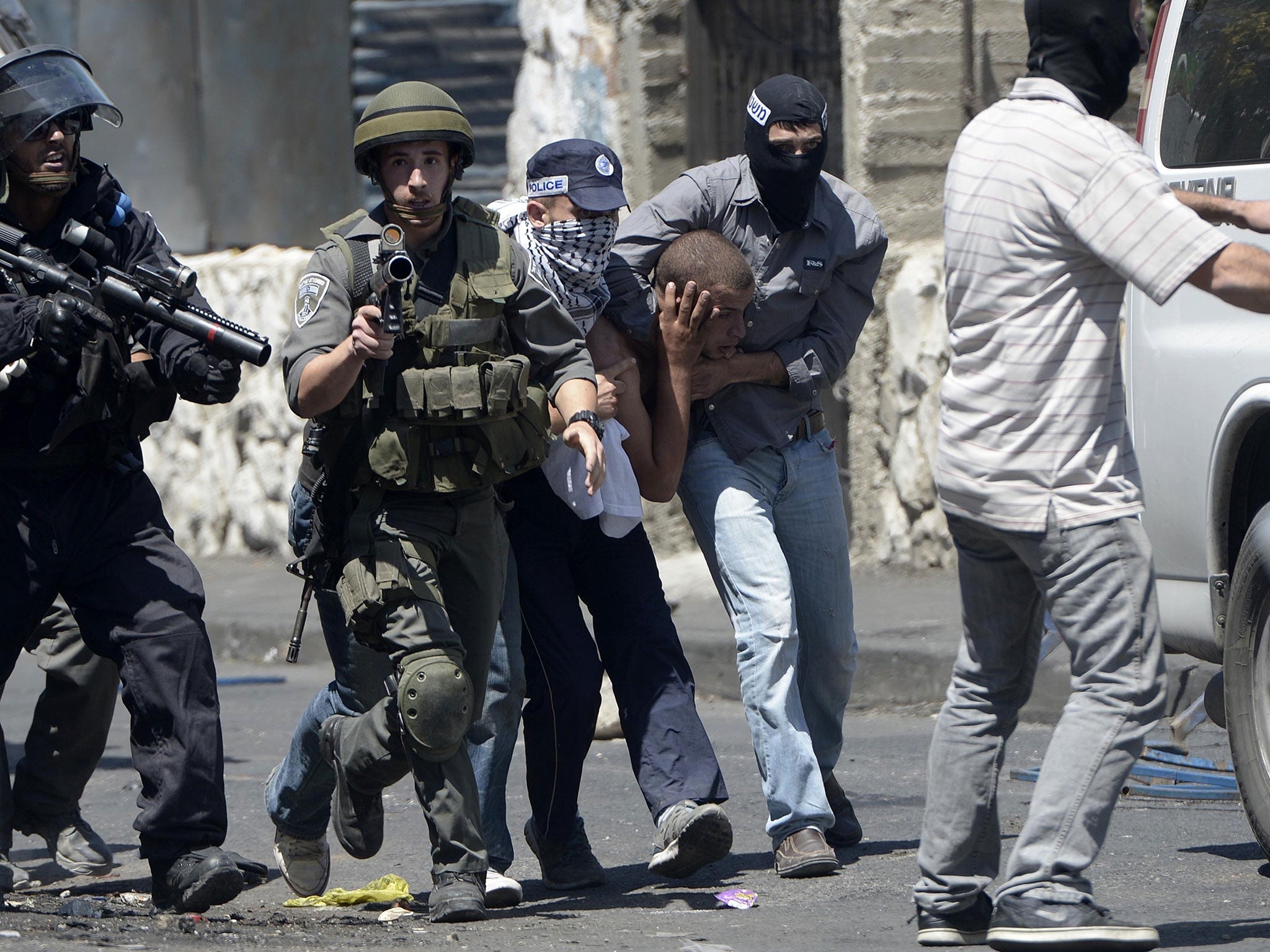 Israeli policemen detain a Palestinian boy during a demonstration