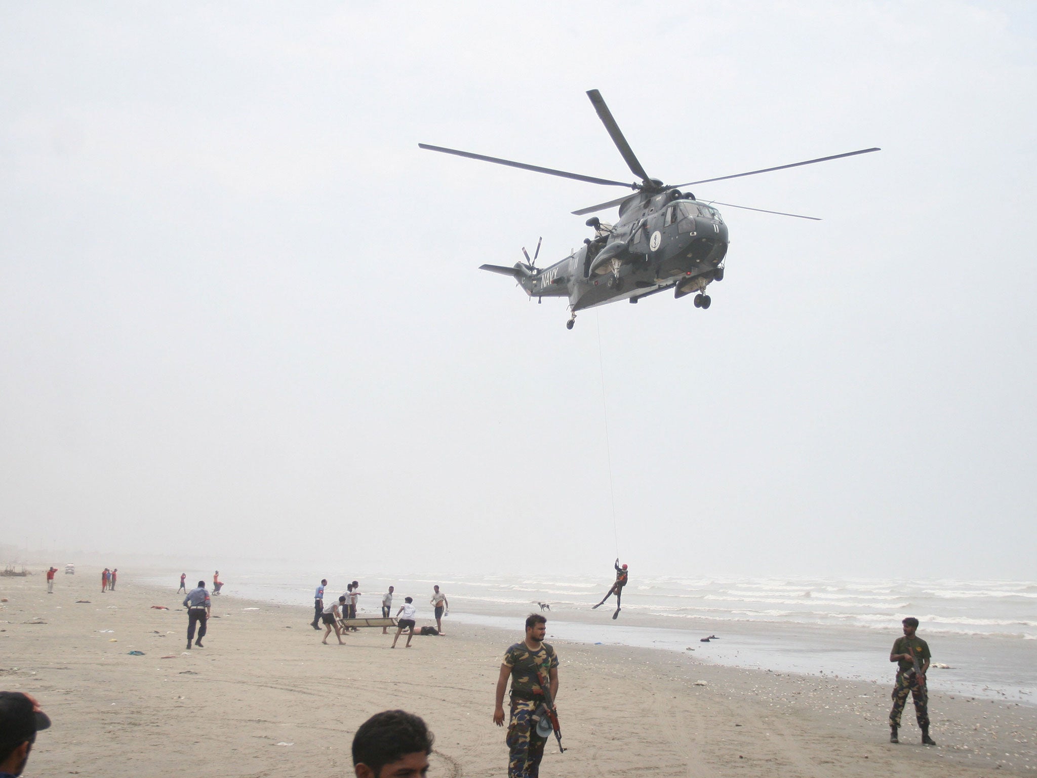 A Pakistani Navy Sea King helicopter flies a search and recovery mission for missing swimmers
