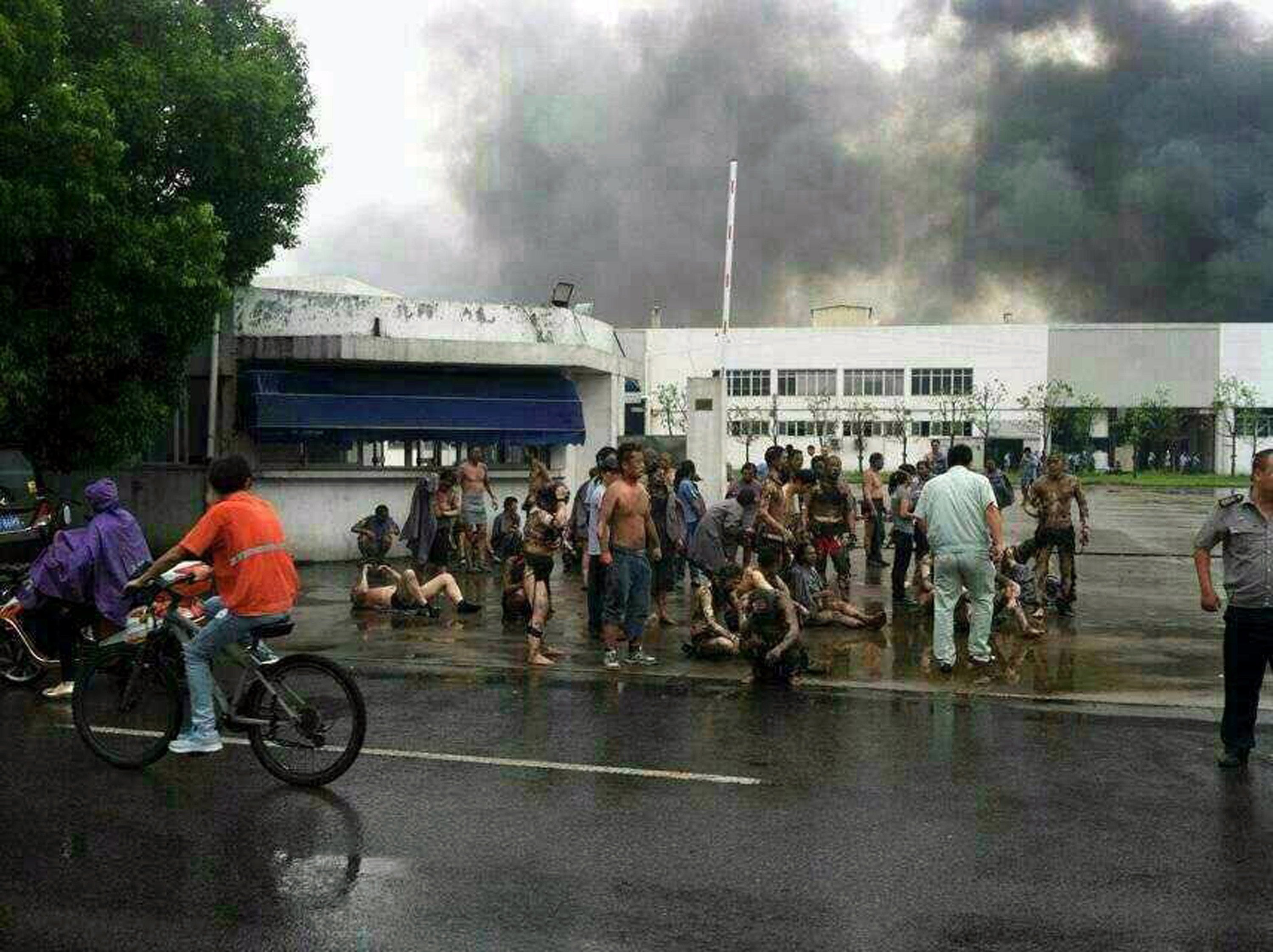 Victims gather outside the gate of a factory after an explosion in Kunshan, east China's Jiangsu province. An explosion killed 65 people as it ripped through a factory in eastern China, a government broadcaster said, injuring 150 in what appeared to be an