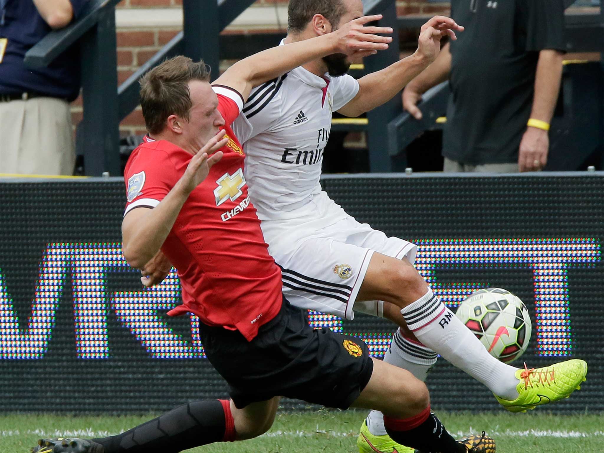Phil Jones of Manchester United clears the ball against Dani Carvajal of Real Madrid during at Michigan Stadium