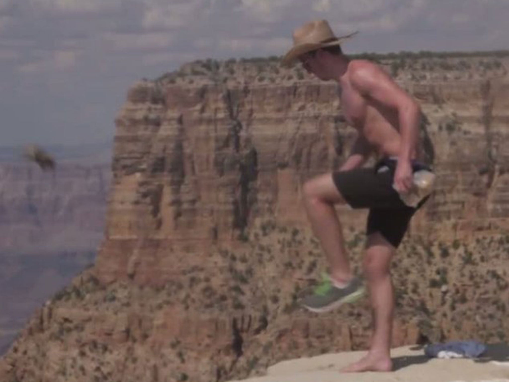 A man is seen kicking a squirrel from a canyon