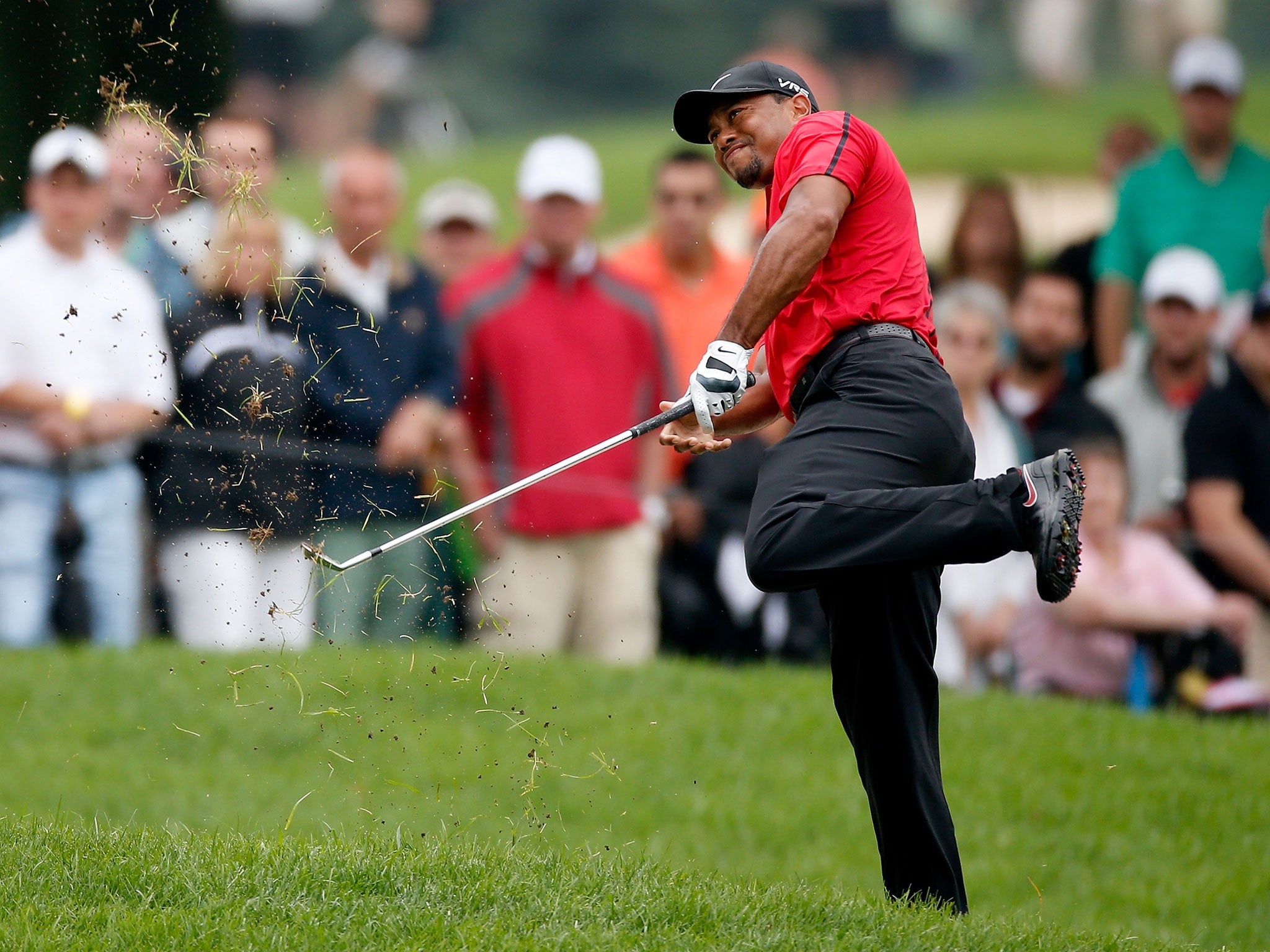 Tiger Woods hits out of the rough awkwardly on the second hole of his final round