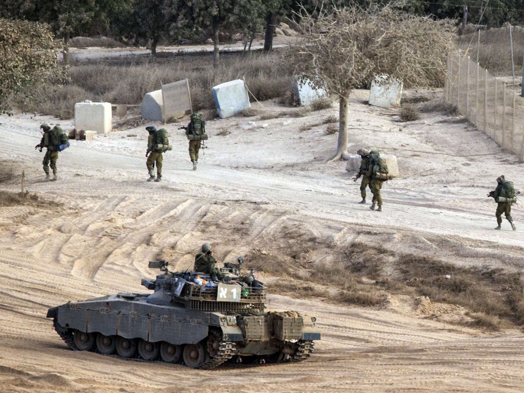 Israeli soldiers walk along Israel's border with the Gaza Strip, on August 4, 2014