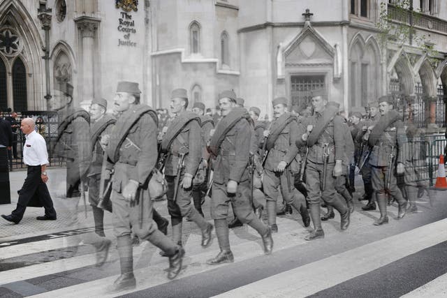 People pass the Royal Courts of Justice next to Serbian soldiers marching in the Lord Mayor's show, London, in the last days of the First World War in November 1918