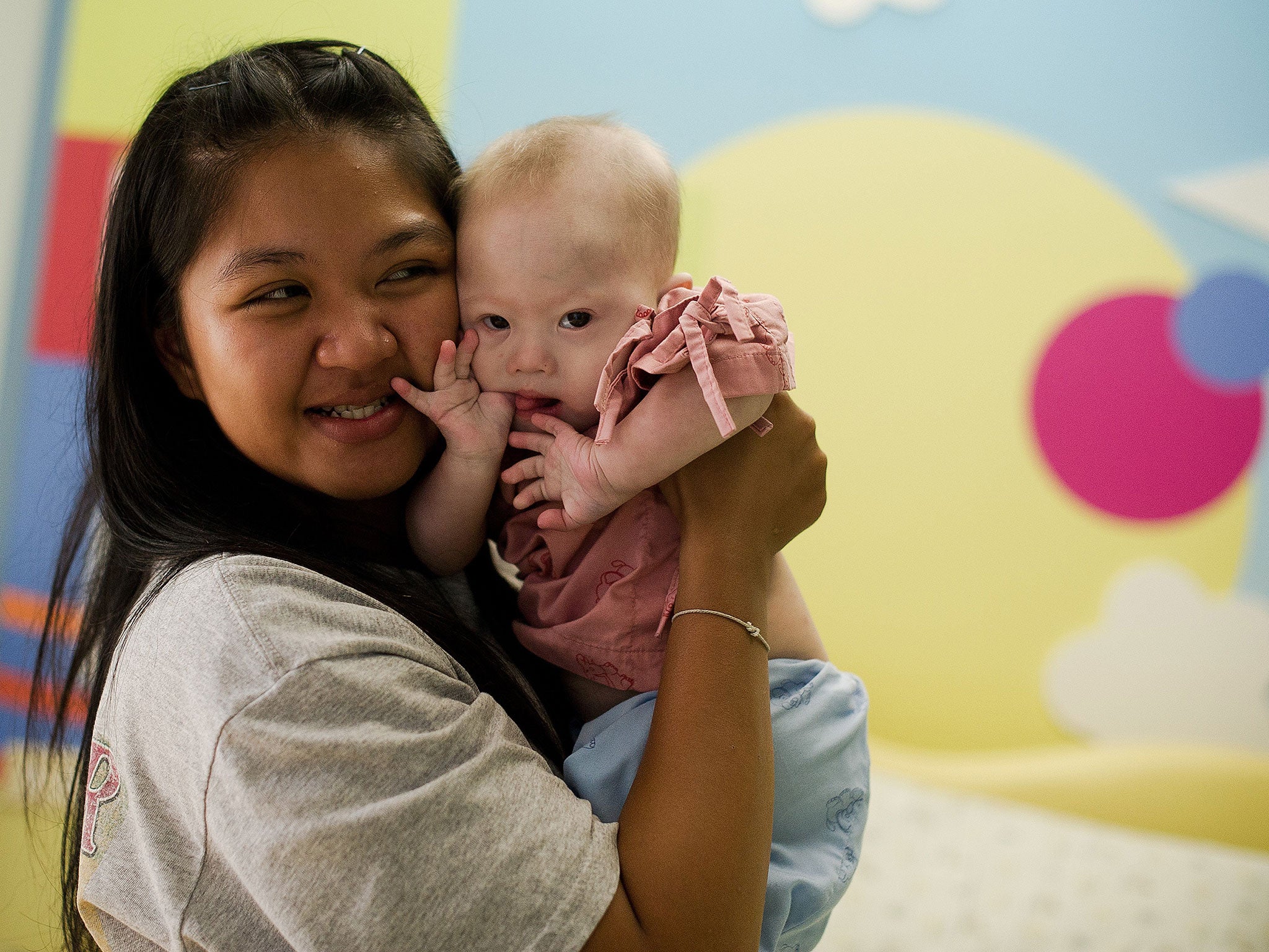Thai surrogate mother Pattaramon Chanbua (L) holds her baby Gammy, born with Down Syndrome, at the Samitivej hospital, Sriracha district in Chonburi province on August 4, 2014. The surrogate mother of a baby reportedly abandoned by his Australian parents