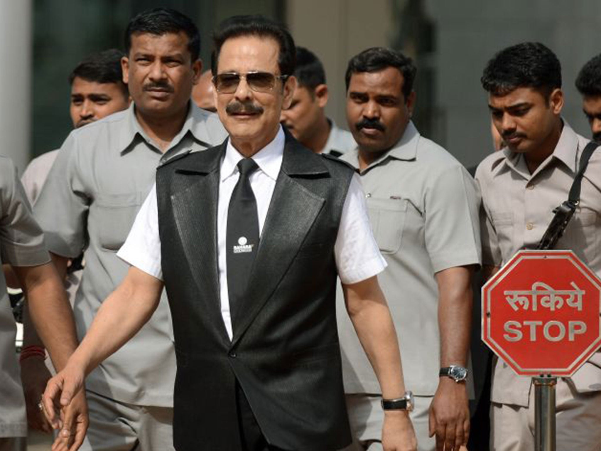 Subrata Roy, flanked by bodyguards, in Mumbai before his arrest