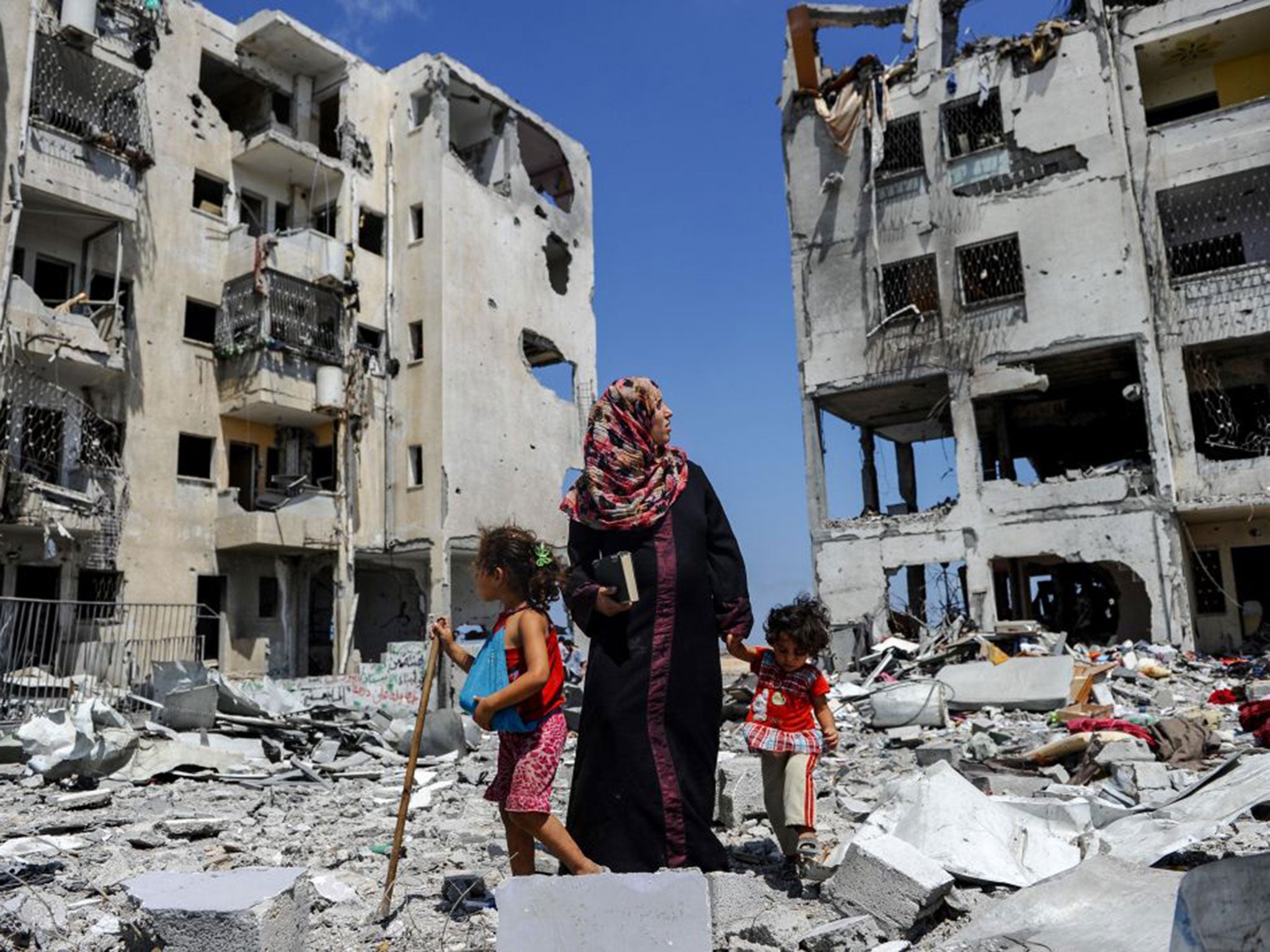 Palestinians sift through the rubble in Beit Lahia, Gaza, in a search for useful belongings