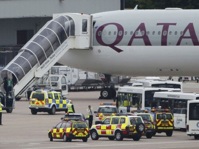 A man is escorted off a Qatar Airways aircraft by police at Manchester airport in Manchester, northern England August 5, 2014