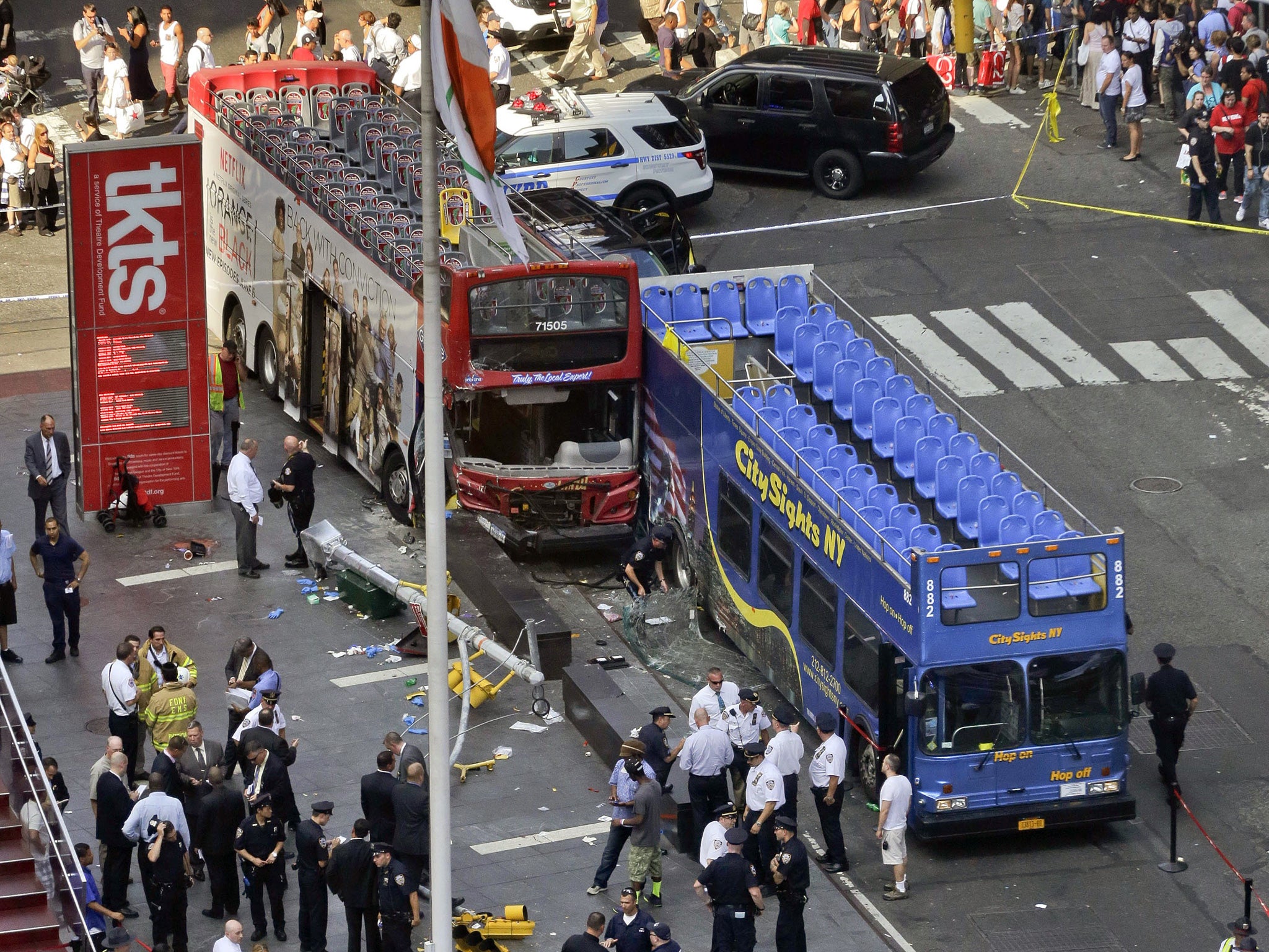 Two double-decker tour buses sit at the corner of 47th Street and 7th Avenue in Times Square after colliding, Tuesday, Aug. 5, 2014, in New York