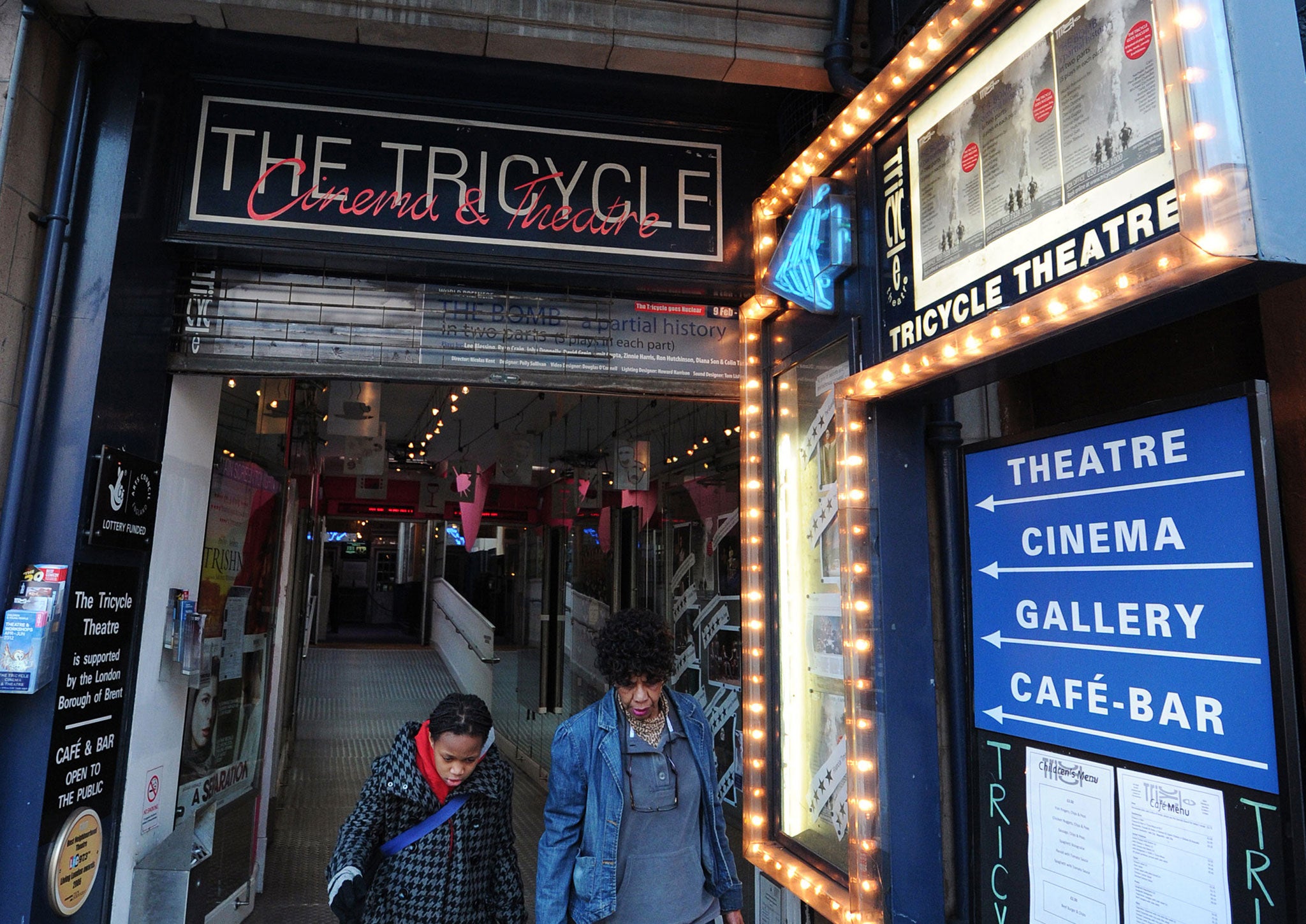 People walk through the entrance of the Tricycle Theatre in north London