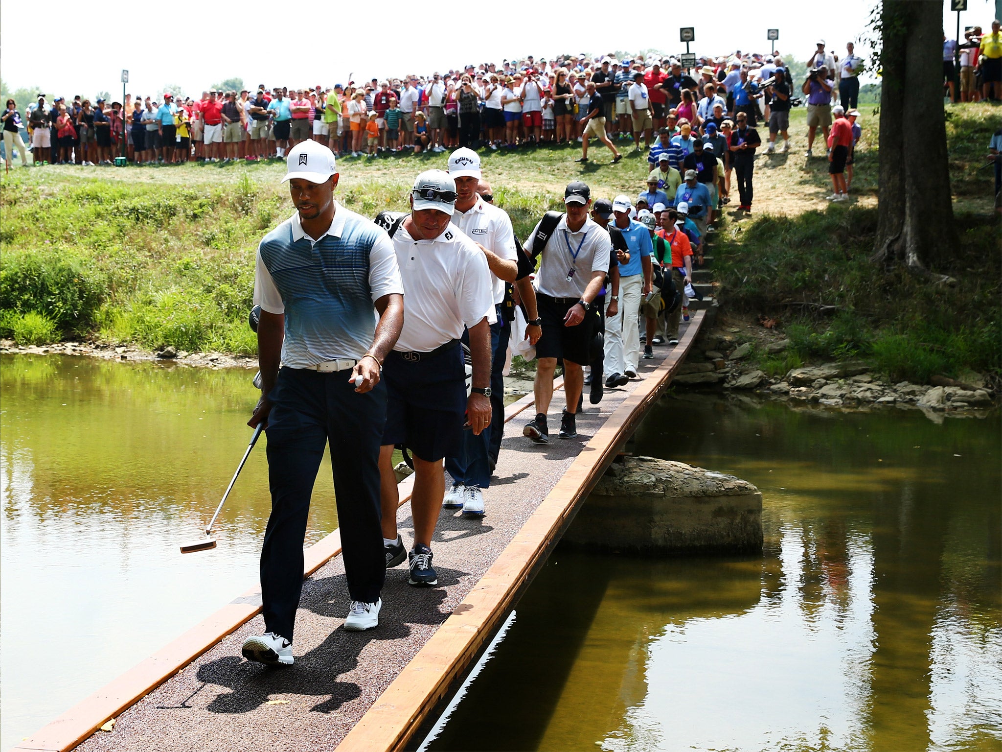Tiger Woods crosses a bridge during a practice round as he sought to prove he had recovered from injury ahead the US PGA Championship
