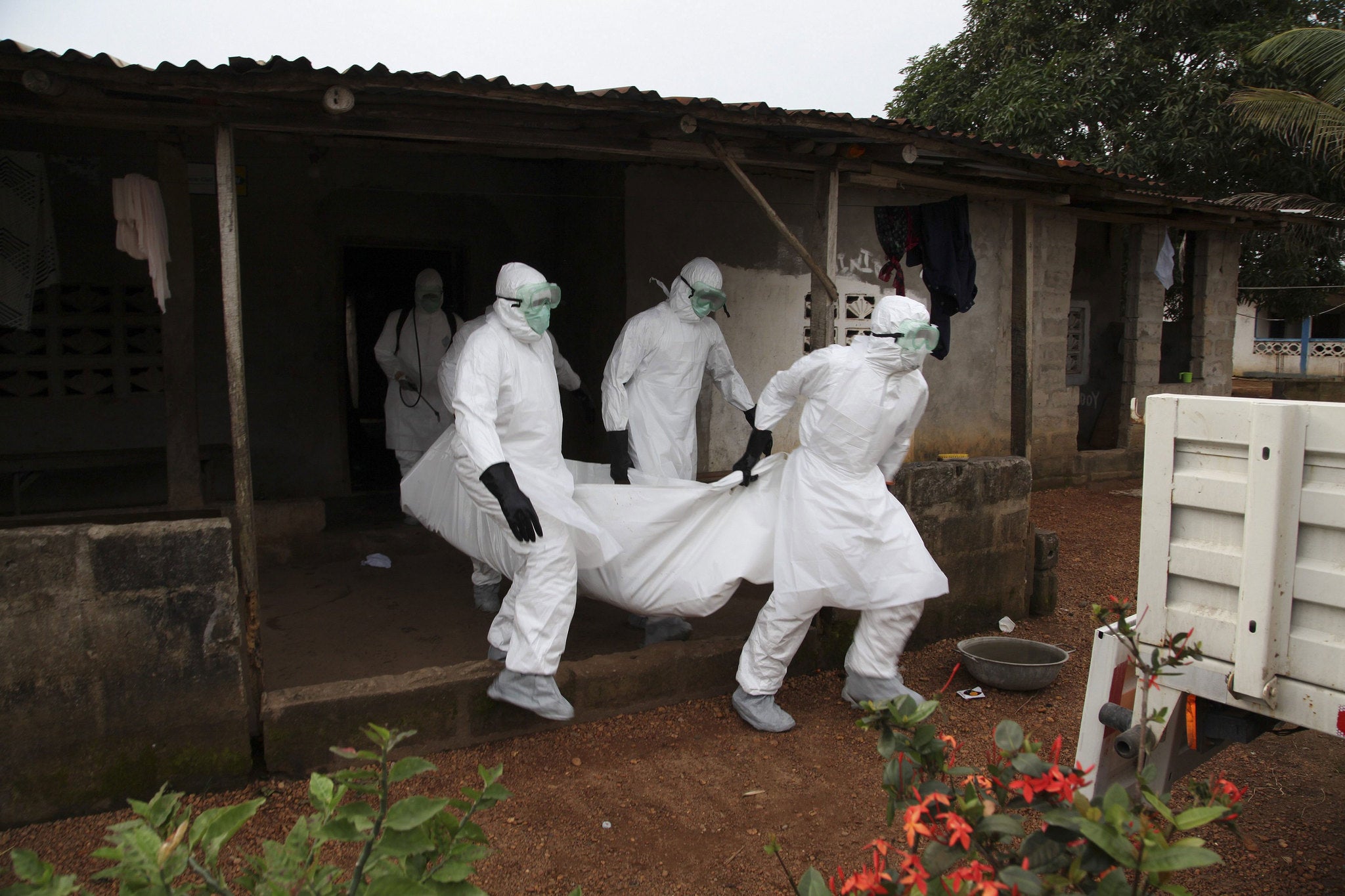 Liberian nurses carry the body of an Ebola victim from a house for burial in the Banjor Community on the outskirts of Monrovia, Liberia 6 August 2014.