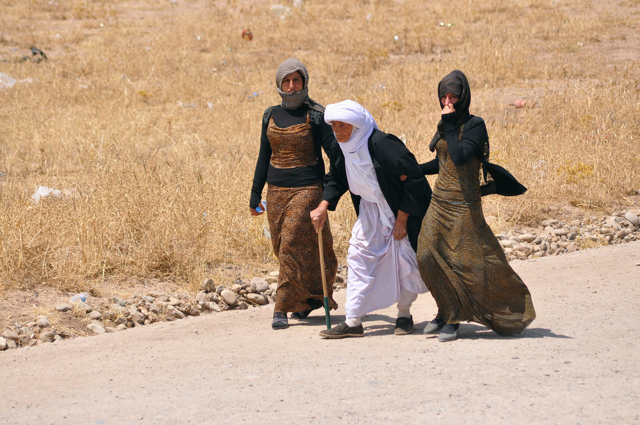 Displaced families from the minority Yazidi sect, fleeing the violence, walk on the outskirts of Sinjar, west of Mosul.