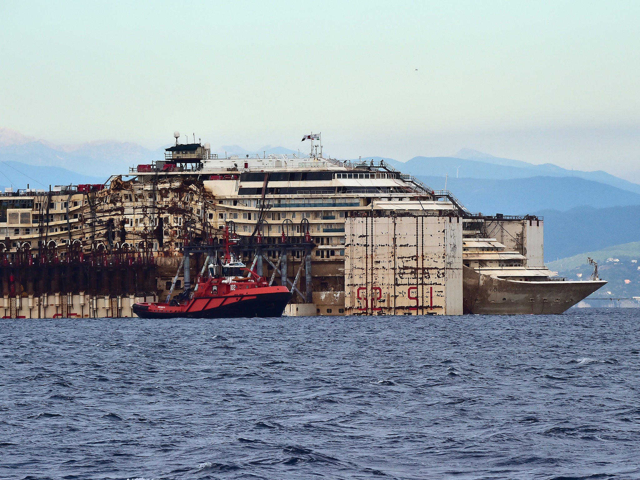 The refloated wreck of the Costa Concordia cruise ship is being dragged to the harbor of Pra di Voltri near Genoa