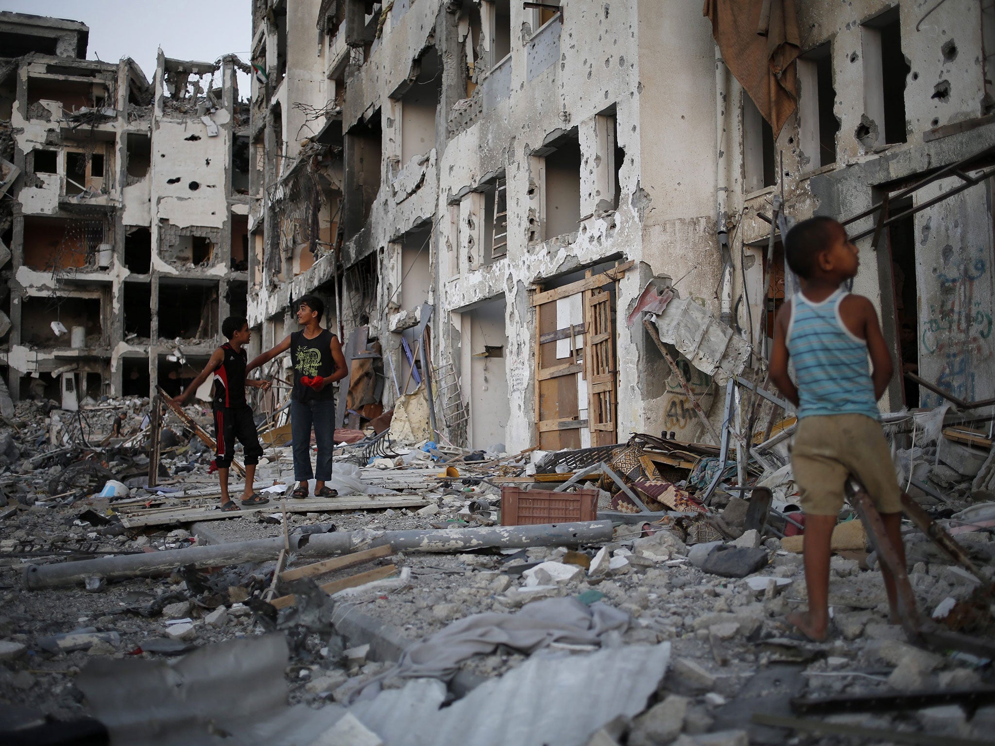 Palestinian boys play among the rubbles of a destroyed AL-Nada towers, hours before a 72-hours ceasefire between Israel and Hamas will come to an end in Beit Lahiya town in the northern Gaza, 07 August 2014