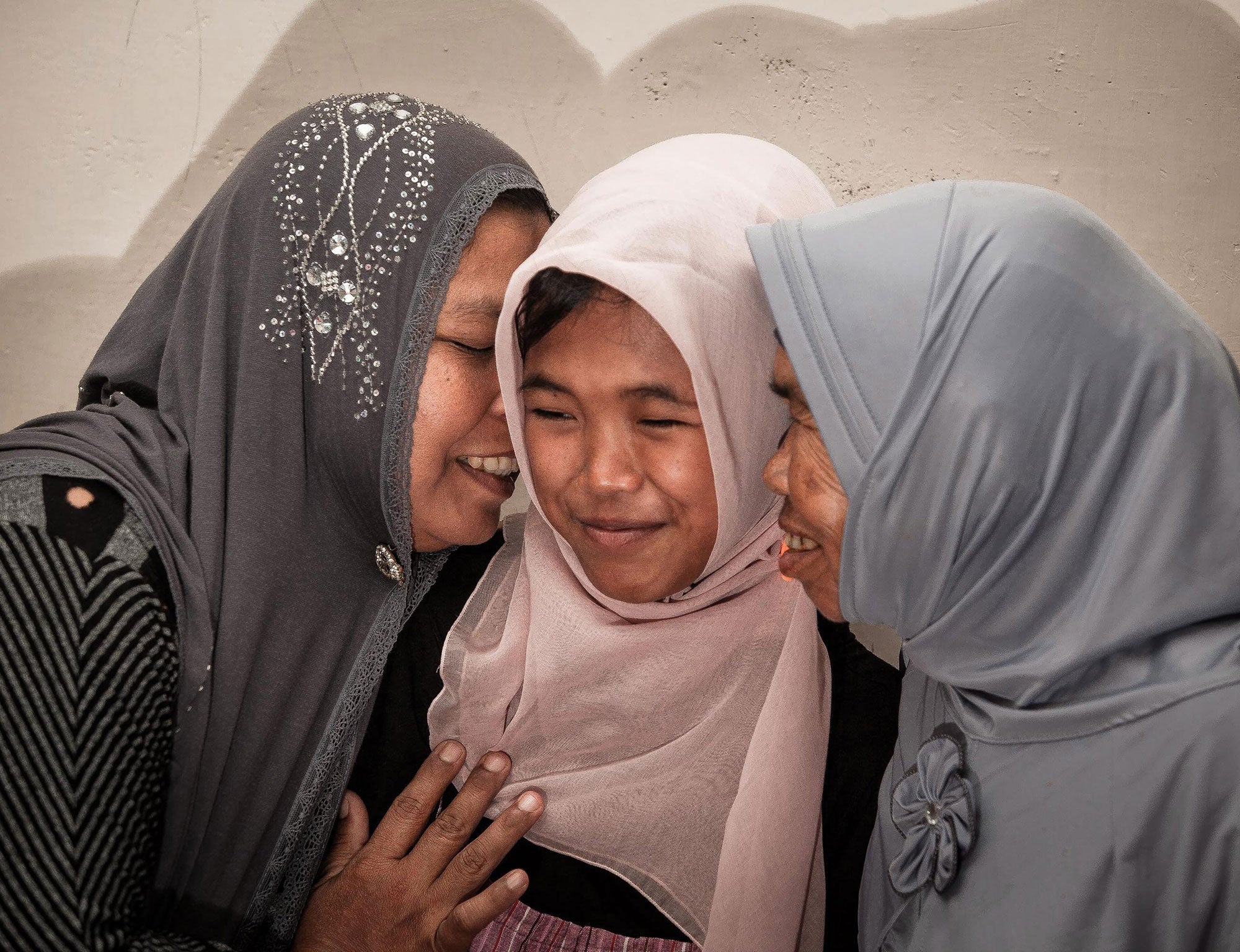 Jamaliah (L) gives a hug to her daughter Raudhatul Jannah (C) after being reunited in Meulaboh, Aceh, northern Sumatra, Indonesia, 07 August 2014.