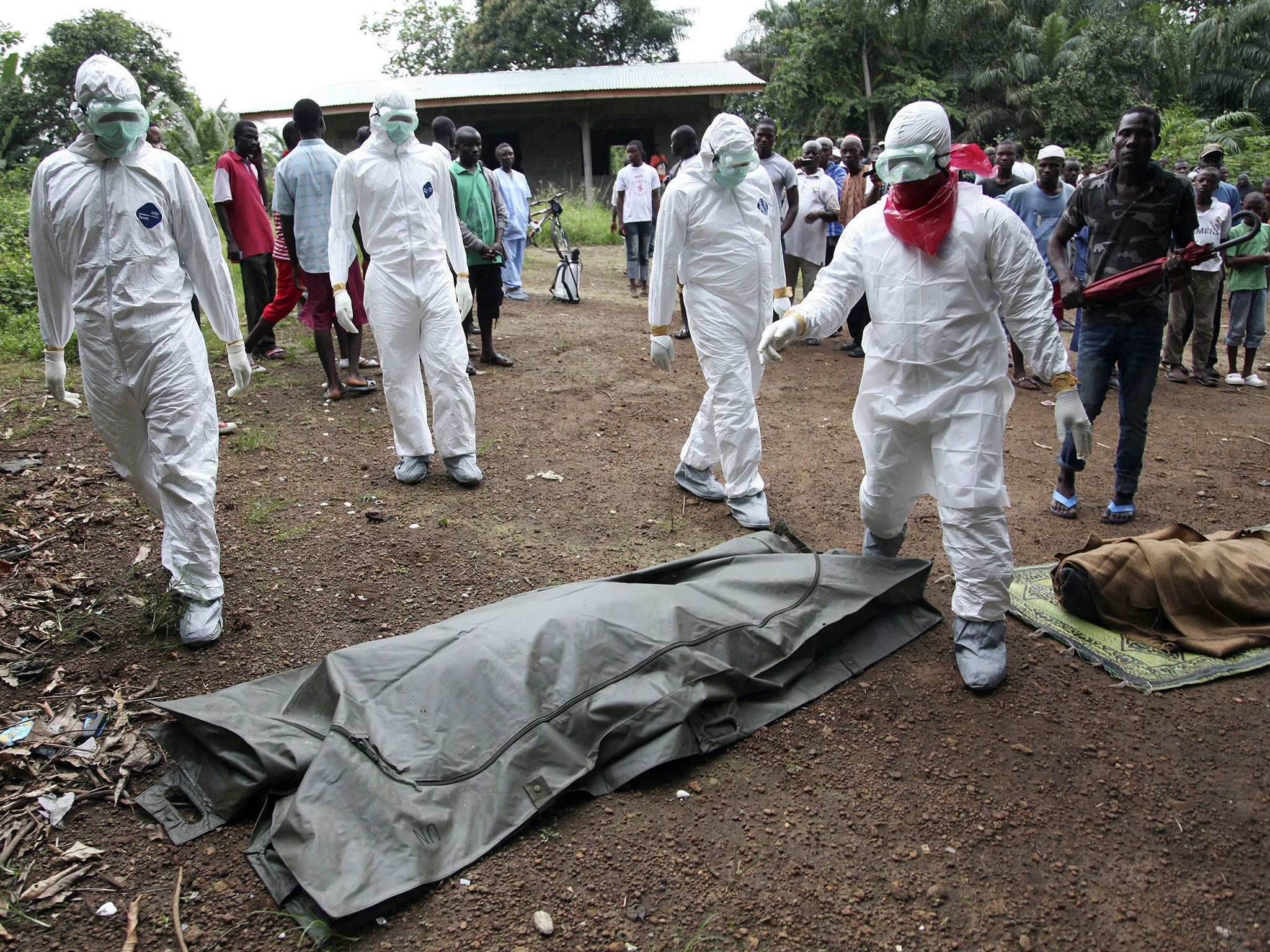 Liberian nurses prepare to bury an Ebola victim yesterday in the Banjor community on the outskirts of Monrovia
