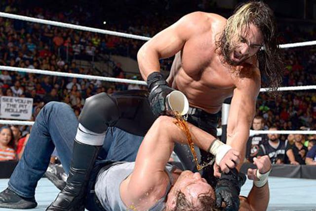 Seth Rollins pours a drink over Dean Ambrose