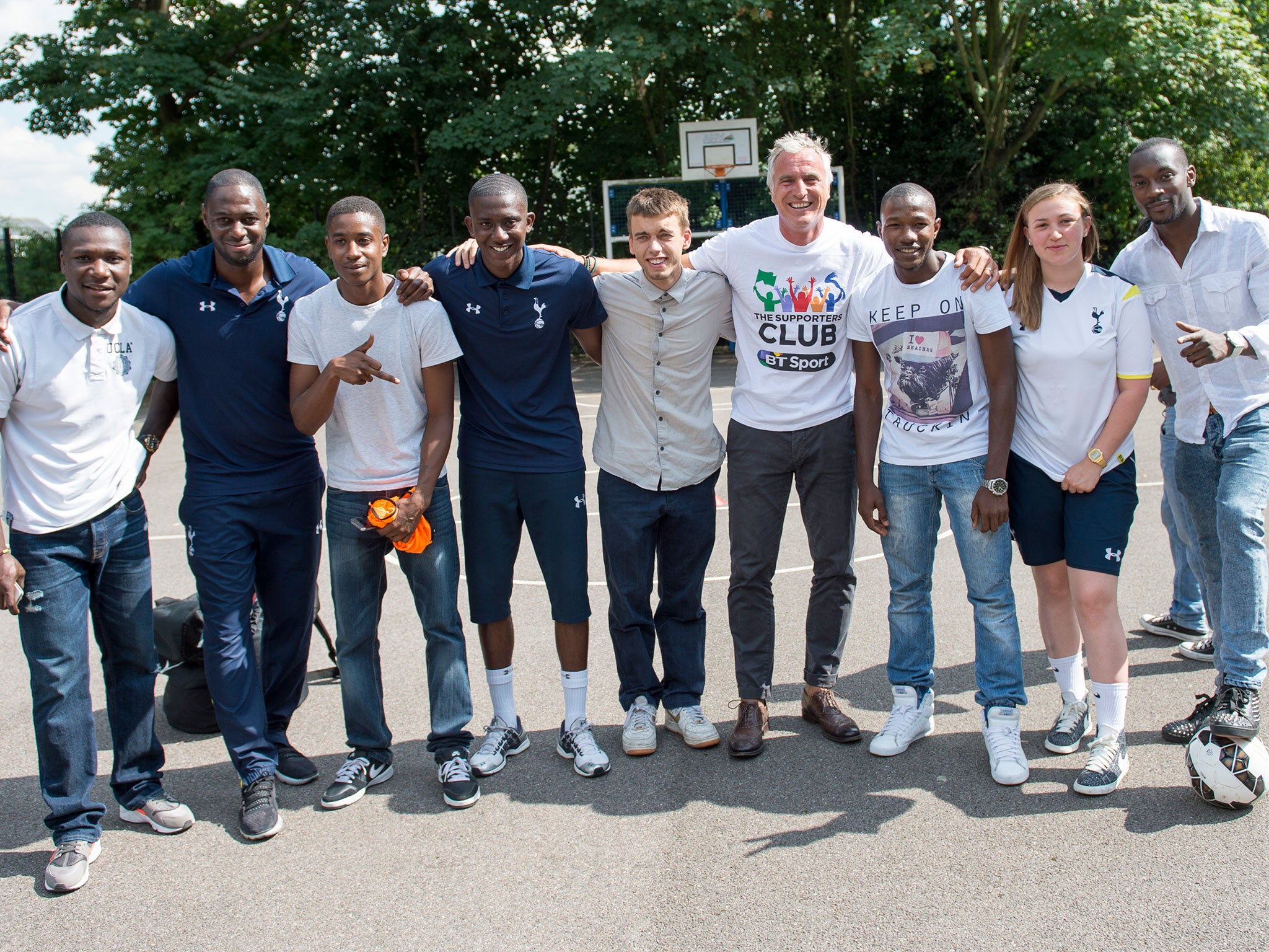 King and Ginola pose with members of the To Care Is To Do program