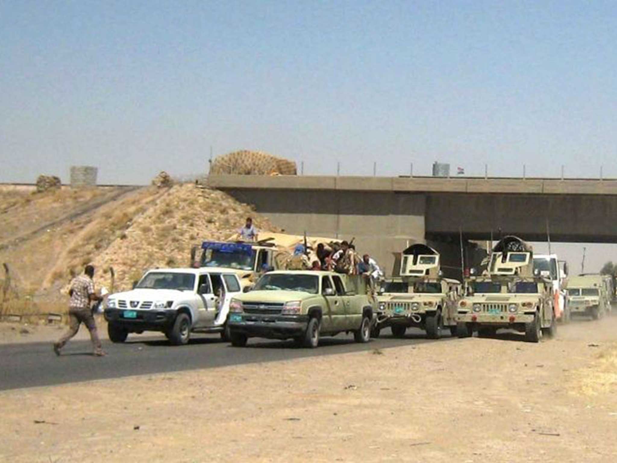 Iraqi soldiers in civilian clothes flee Kirkuk on the back of a truck