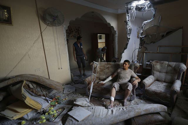 An injured Palestinian sits inside his home yesterday after it was hit by an Israeli military strike on the Jabaliya refugee camp in the northern Gaza Strip