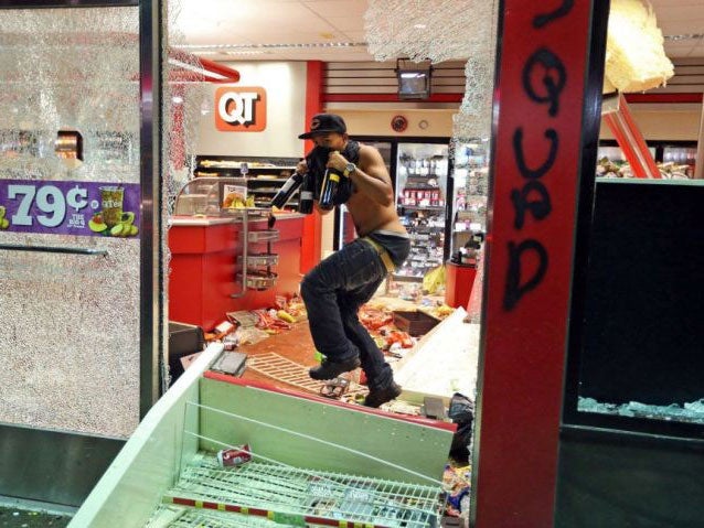 A man leaving a looted shop in St Louis following a vigil for Michael Brown on Sunday